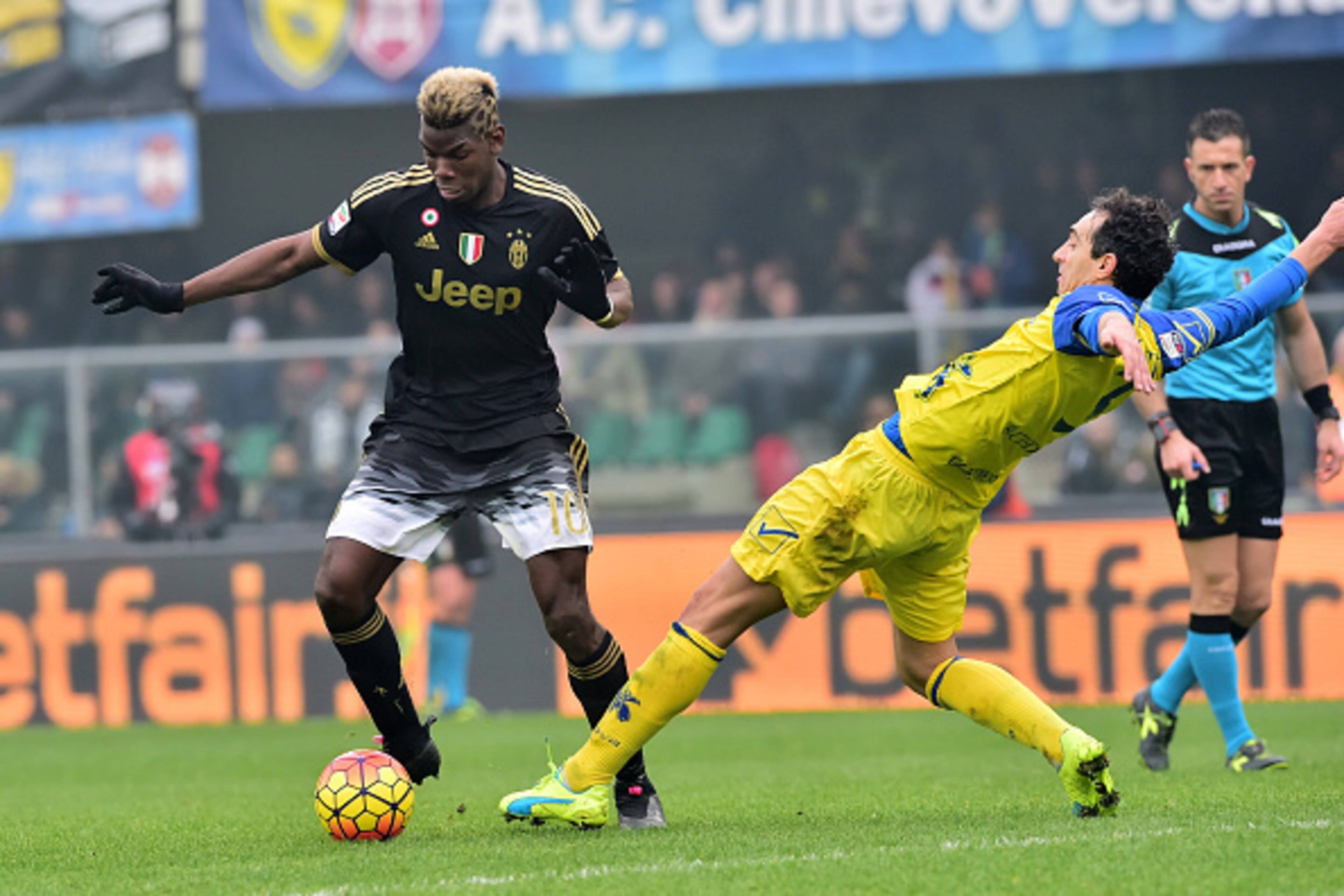 Juventus' midfielder from France Paul Pogba fights for the ball with Chievo's defender from Italy Dario Dainelli (R) during the Serie A football match between Chievo Verona and Juventus on January 31, 2016 at Bentegodi Stadium in Verona.  / AFP / GIUSEPPE