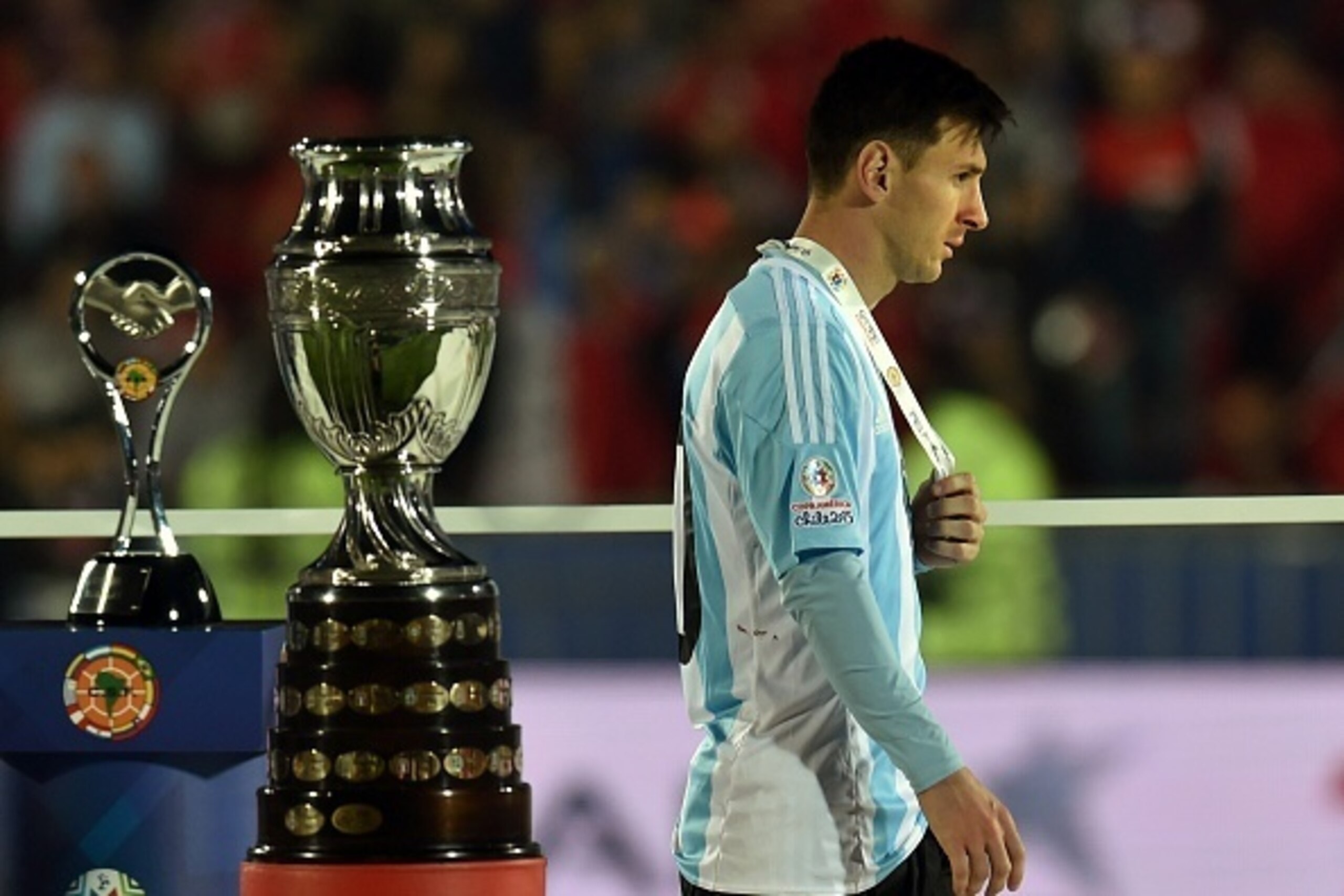 Argentina's forward Lionel Messi walks with the second place medal of the 2015 Copa America football championship, in Santiago, Chile, on July 4, 2015. Chile defeated Argentina 4-1 in the penalty shootout.   AFP PHOTO / RODRIGO ARANGUA        (Photo credi