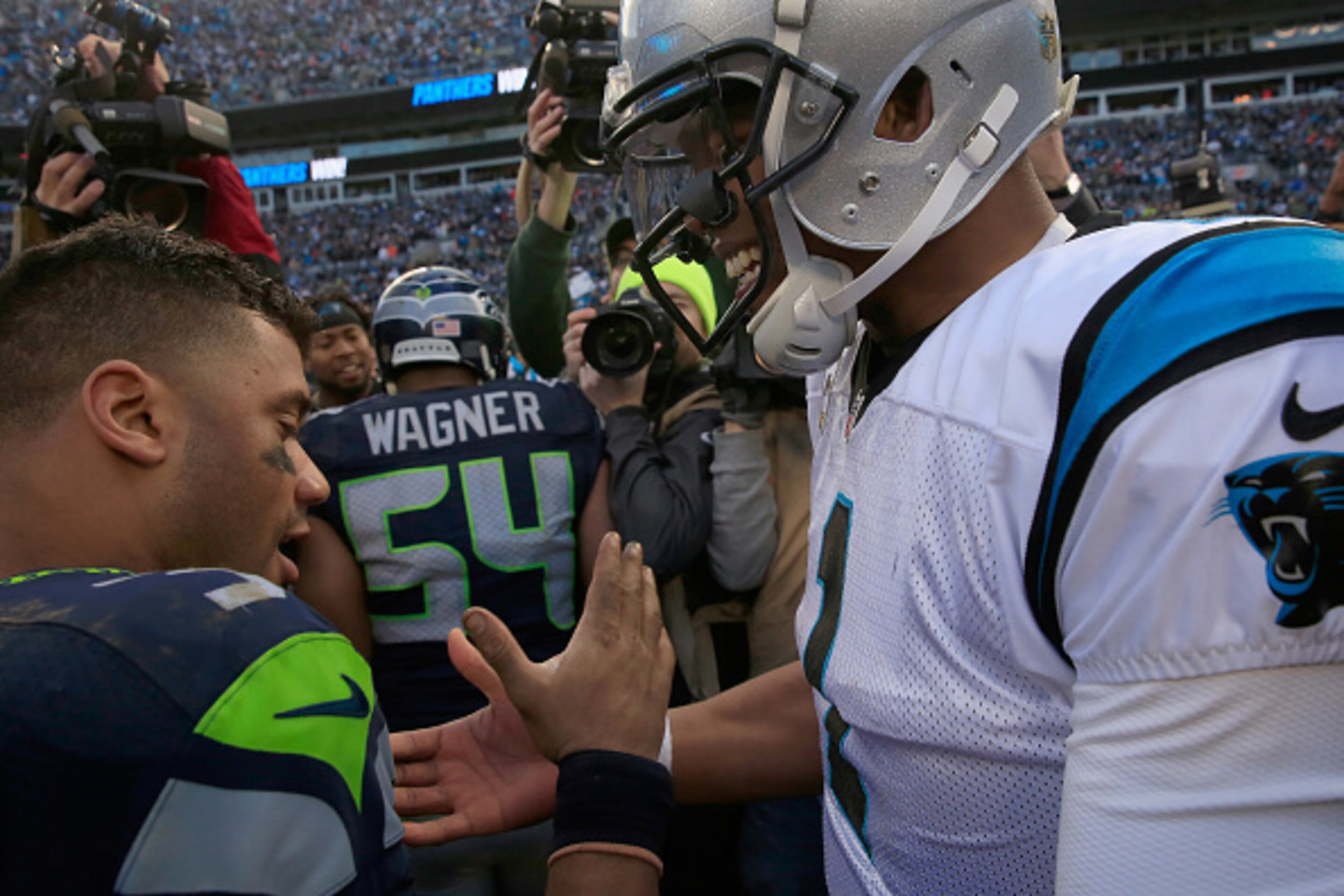 CHARLOTTE, NC - JANUARY 17:  Cam Newton #1 of the Carolina Panthers meets  Russell Wilson #3 of the Seattle Seahawks on the field after the NFC Divisional Playoff Game at Bank of America Stadium on January 17, 2016 in Charlotte, North Carolina.  (Photo by