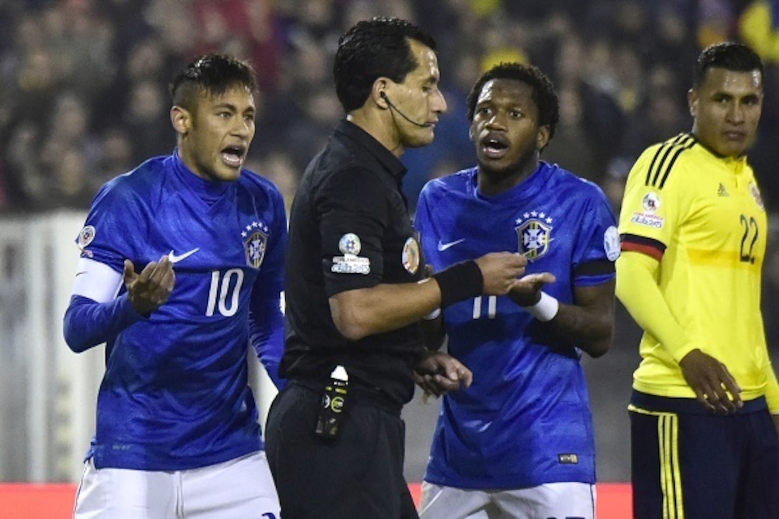 Brazil's forward Neymar (L) and Brazil's midfielder Fred argue with Chilean referee Enrique Osses during their Copa America football match at the Estadio Monumental David Arellano in Santiago, Chile, on June 17, 2015.       AFP PHOTO / LUIS ACOSTA        