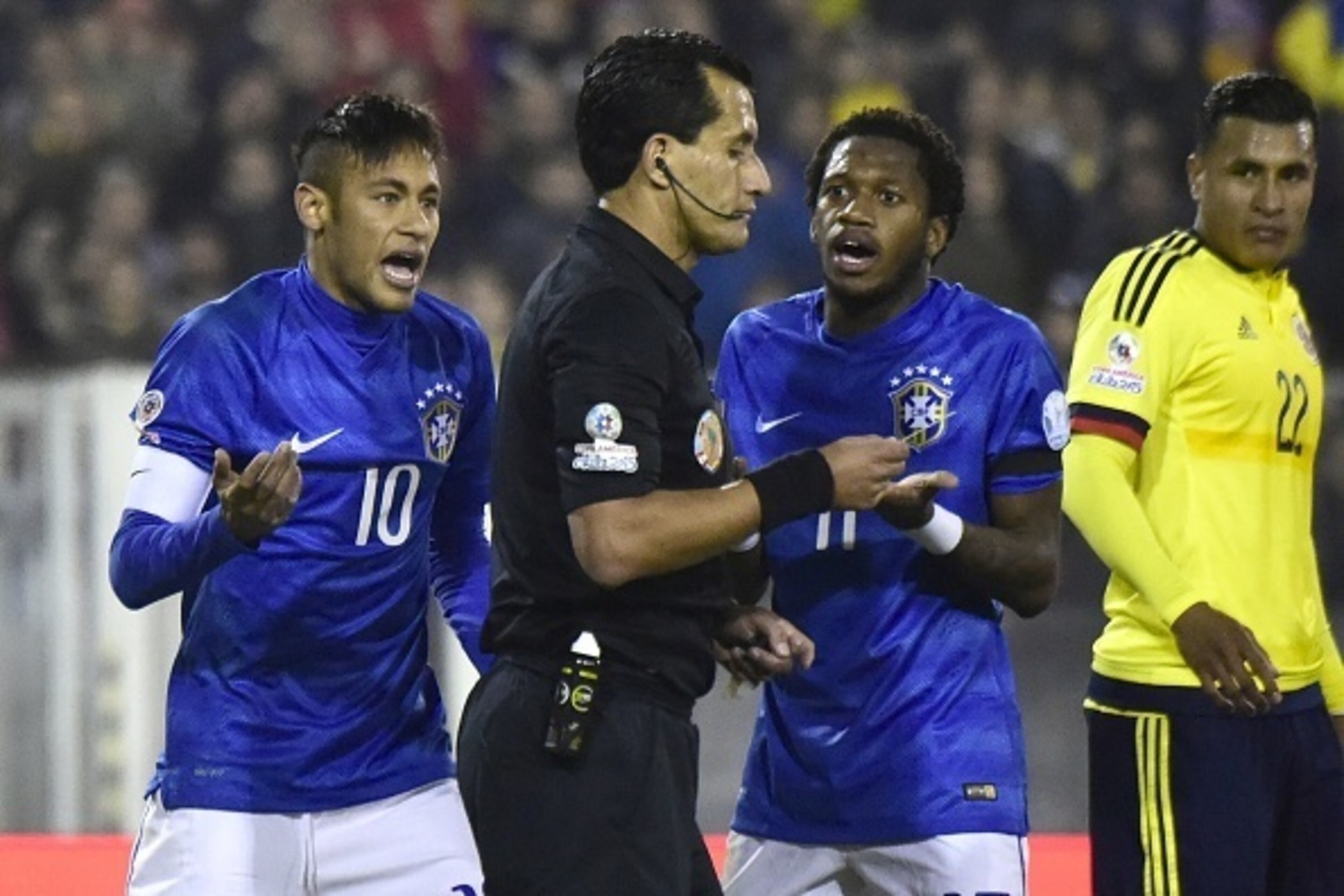 Brazil's forward Neymar (L) and Brazil's midfielder Fred argue with Chilean referee Enrique Osses during their Copa America football match at the Estadio Monumental David Arellano in Santiago, Chile, on June 17, 2015.       AFP PHOTO / LUIS ACOSTA        
