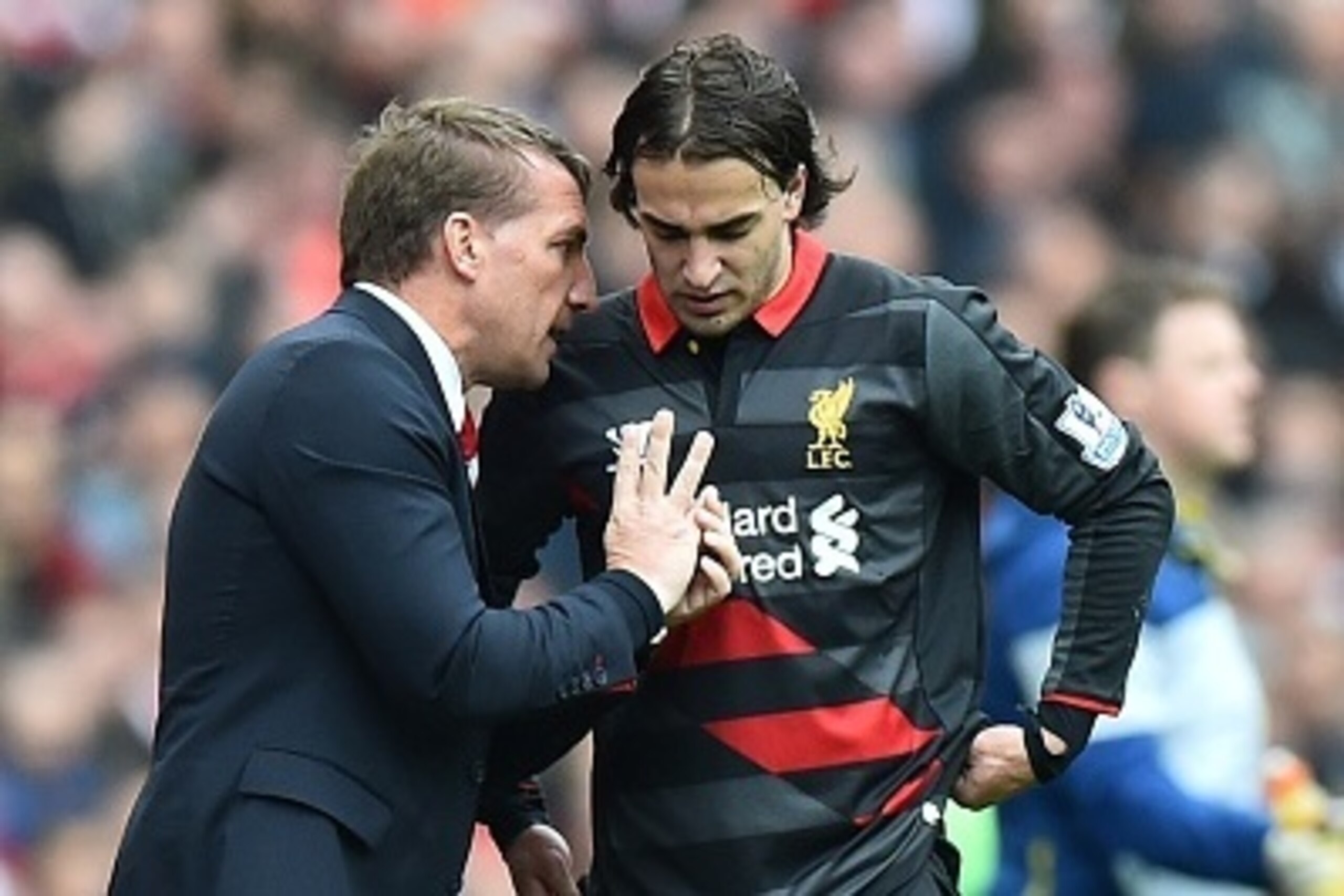 Liverpool's Northern Irish manager Brendan Rodgers (L) speaks with Liverpool's Serbian midfielder Lazar Markovic during the English Premier League football match between Arsenal and Liverpool at the Emirates Stadium in London on April 4, 2015. AFP PHOTO /