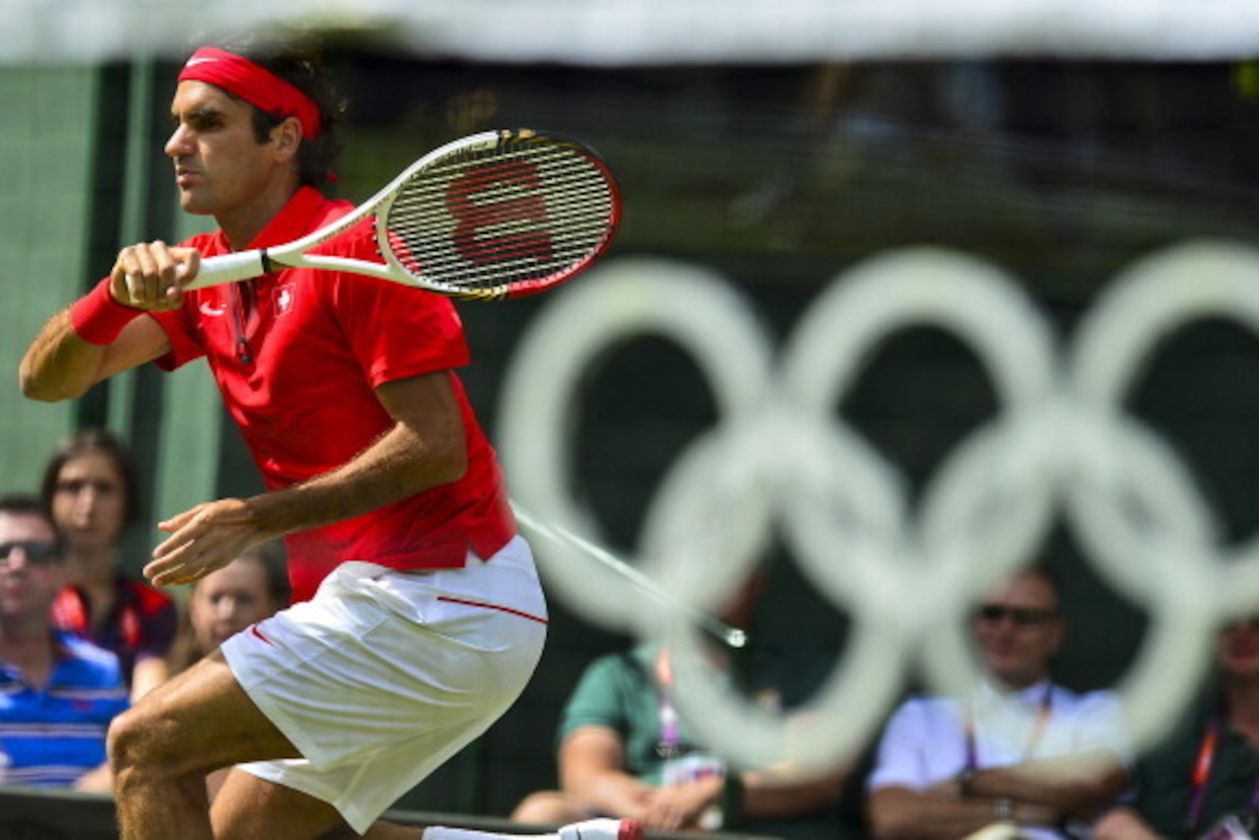 Switzerland's Roger Federer returns the ball to France's Julien Benneteau during their men's single tennis match second round during the London 2012 Olympic Games in London on July 30, 2012.       AFP PHOTO/Luis Acosta        (Photo credit should read LUI