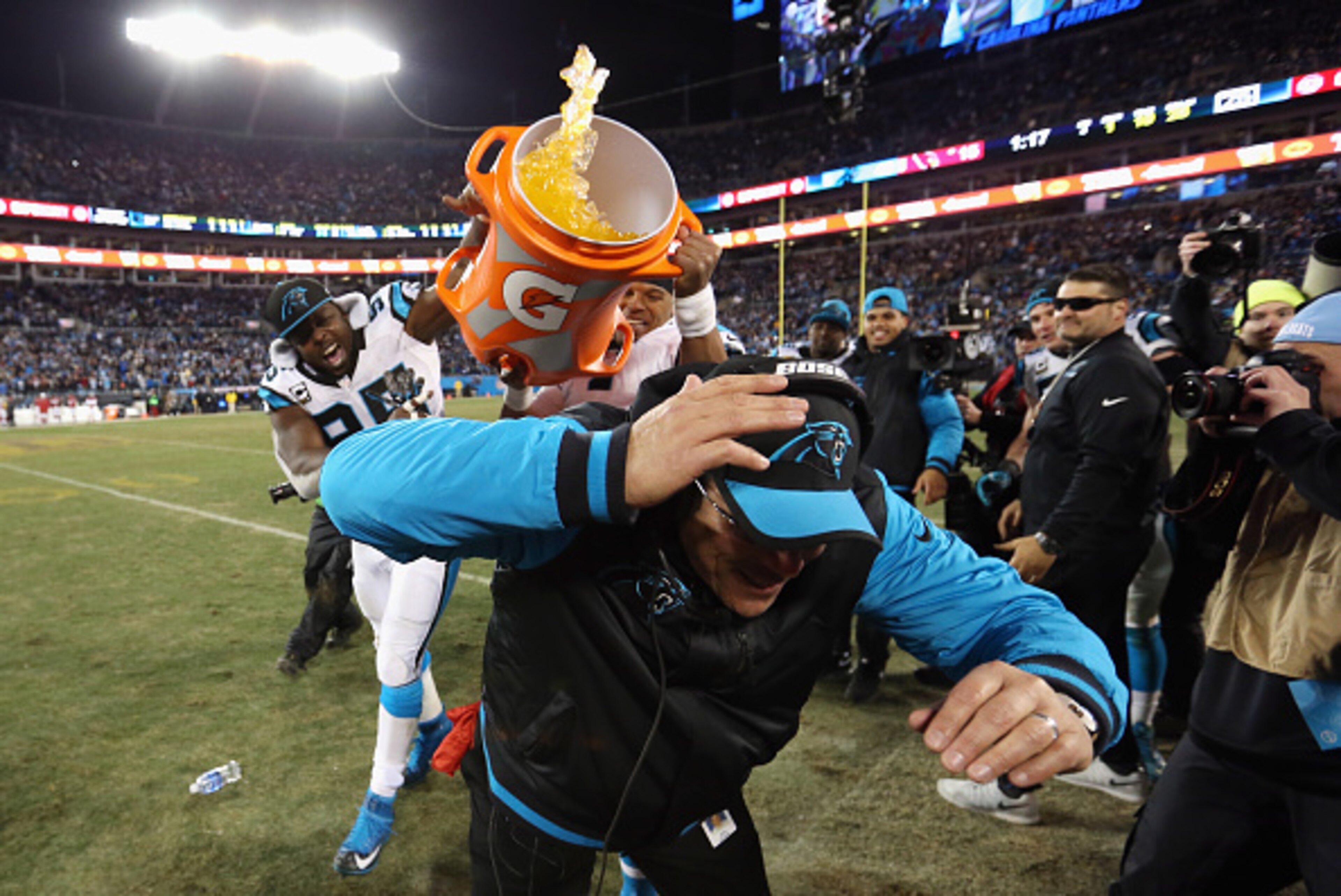 CHARLOTTE, NC - JANUARY 24:  Head coach Ron Rivera of the Carolina Panthers is doused with Gatorade by Charles Johnson #95 and Cam Newton #1 after the Carolina Panthers defeat the Arizona Cardinals with a score of 49 to 15 in the NFC Championship Game at 
