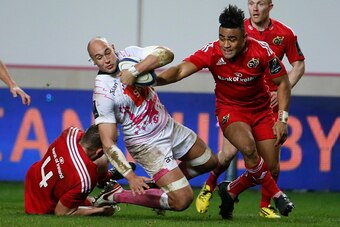 Stade Francais Paris' Italian Number Eight Sergio Parisse (C) is tackled by Munster's Irish lock Dave Foley (L) and Munster's center from New Zealand Francis Saili (R) during the European Champions Cup rugby union match between Stade Francais and Munster 