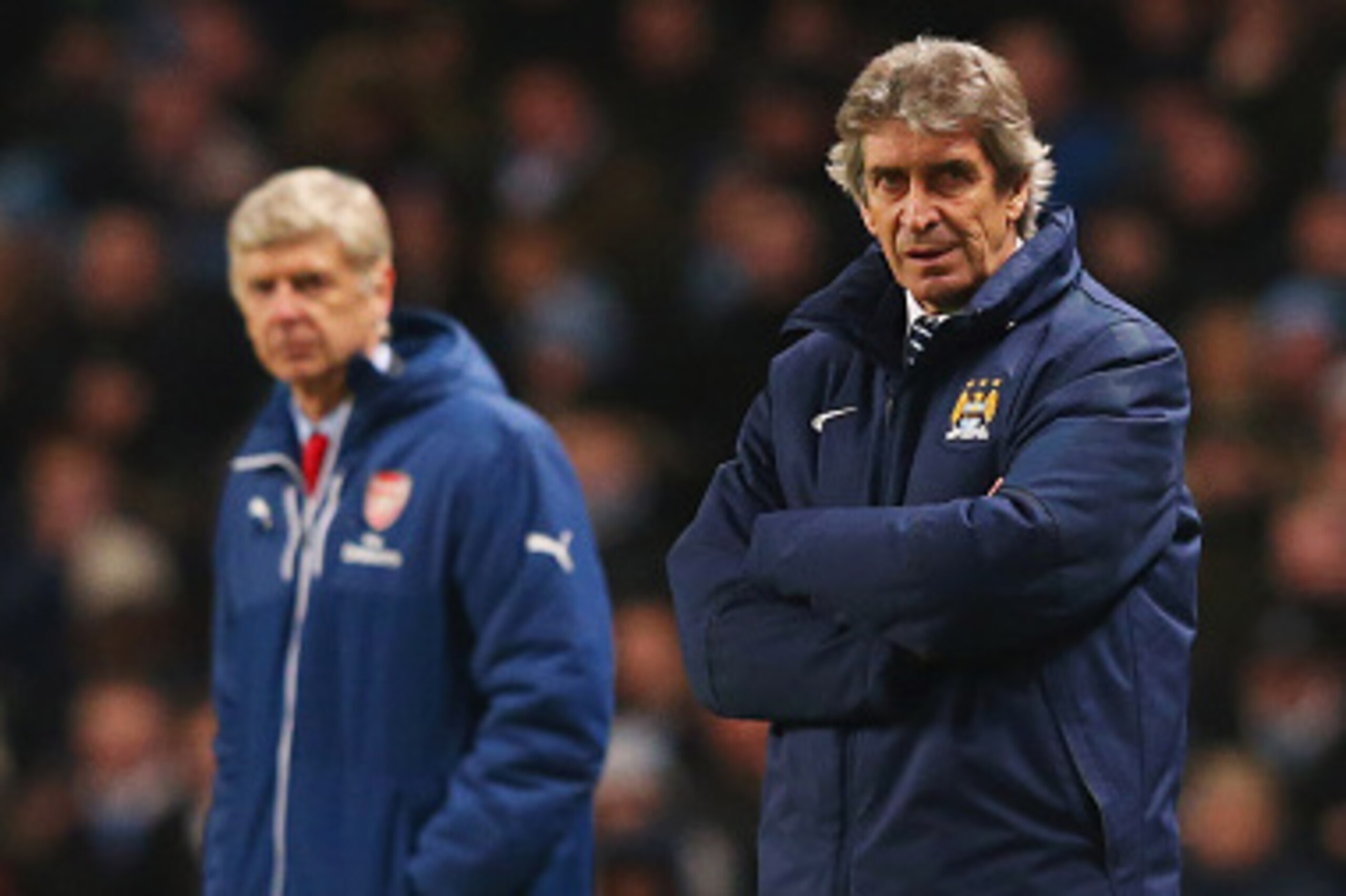 MANCHESTER, ENGLAND - JANUARY 18:  Manuel Pellegrini manager of Manchester City and Arsene Wenger manager of Arsenal look on from the touchline during the Barclays Premier League match between Manchester City and Arsenal at Etihad Stadium on January 18, 2