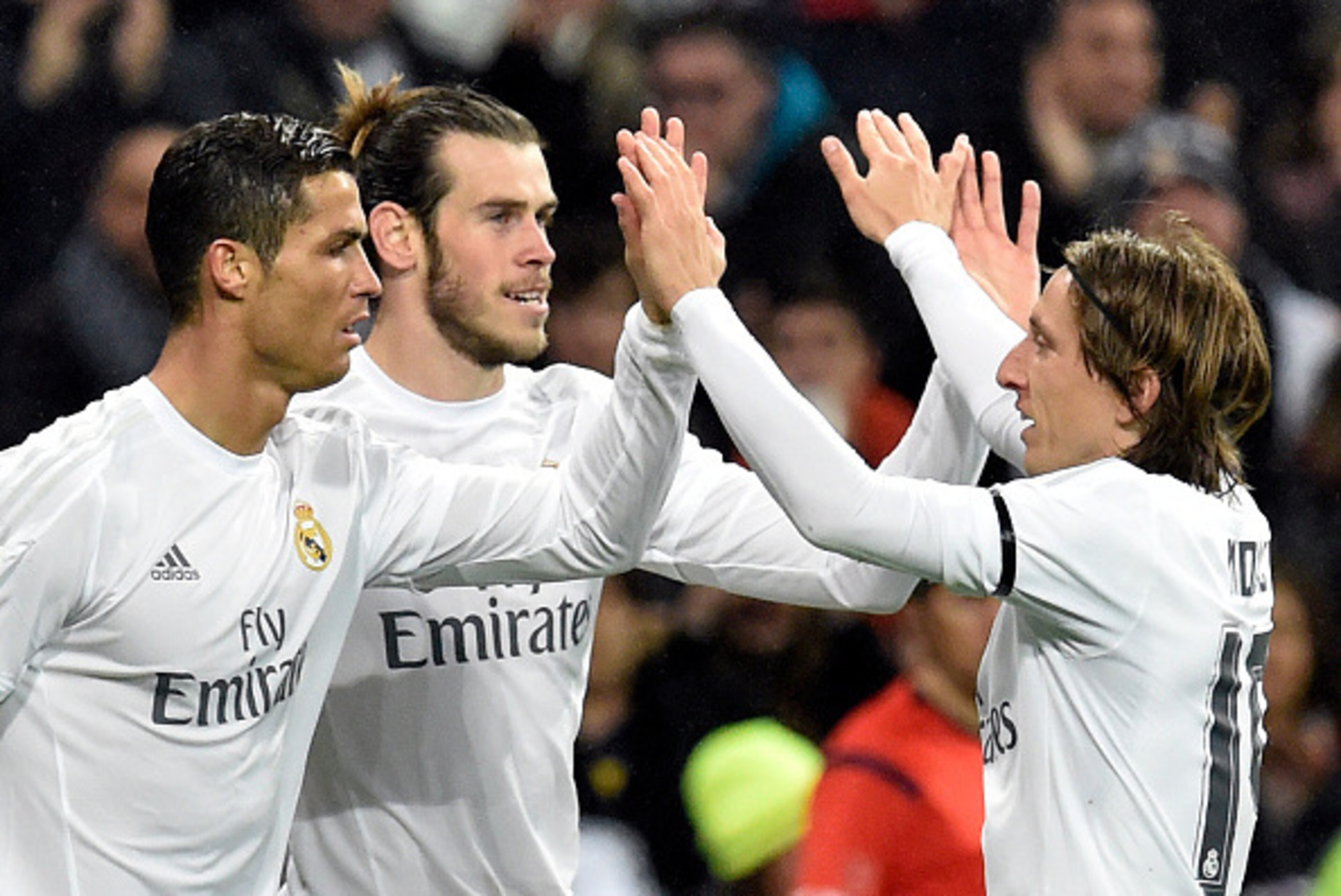Real Madrid's Welsh forward Gareth Bale (C) is congratulated by Real Madrid's Portuguese forward Cristiano Ronaldo (L) and Real Madrid's Croatian midfielder Luka Modric after scoring during the Spanish league football match Real Madrid CF vs RC Deportivo 