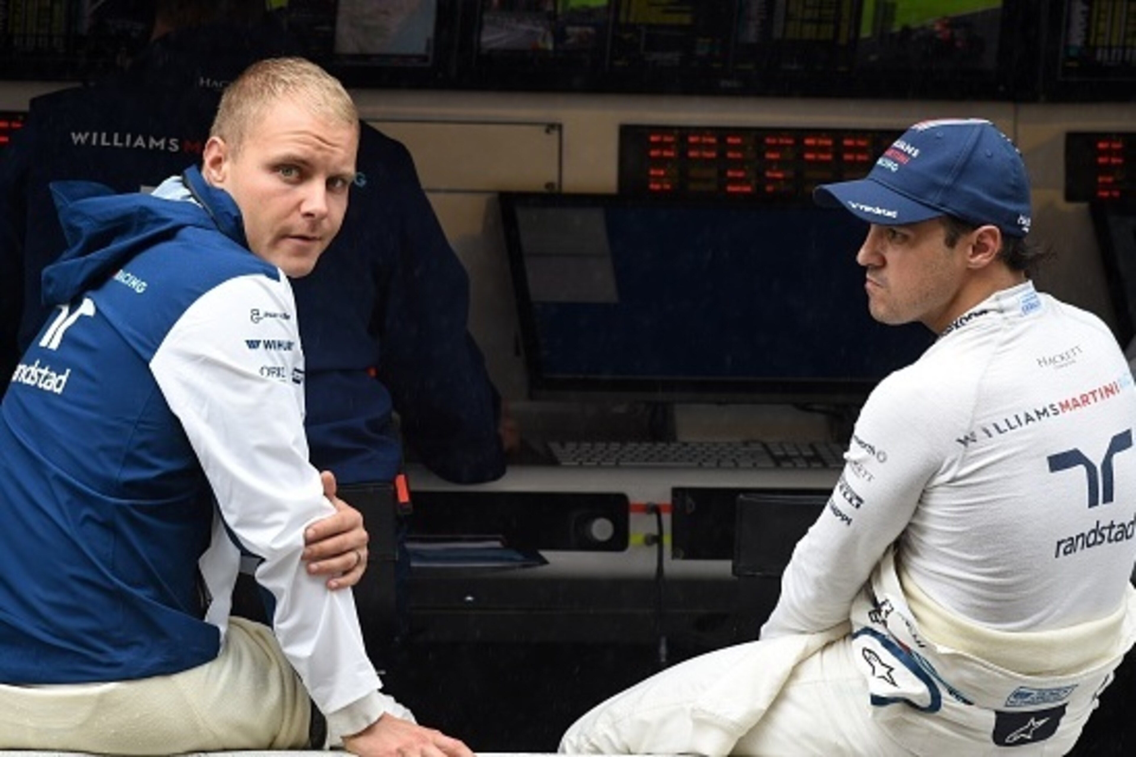 Williams drivers Valtteri Bottas of Finland (L) and Felipe Massa of Brazil (R) chat on the pit wall during the second practice session at the Formula One Japanese Grand Prix in Suzuka on September 25, 2015.    AFP PHOTO / TOSHIFUMI KITAMURA        (Photo 