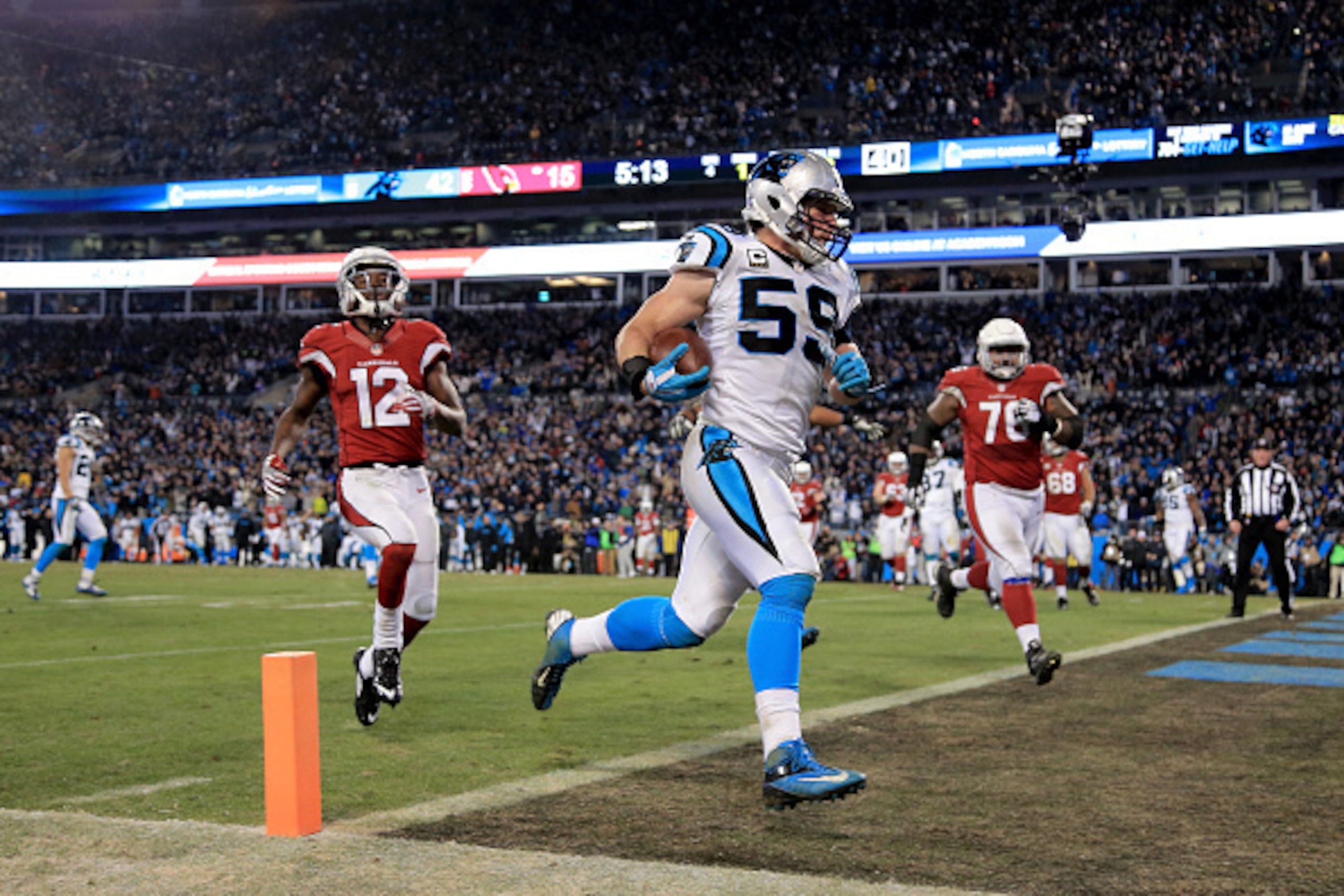 CHARLOTTE, NC - JANUARY 24:  Luke Kuechly #59 of the Carolina Panthers scores a touchdown after intercepting a pass in the fourth quarter against the Arizona Cardinals during the NFC Championship Game at Bank of America Stadium on January 24, 2016 in Char