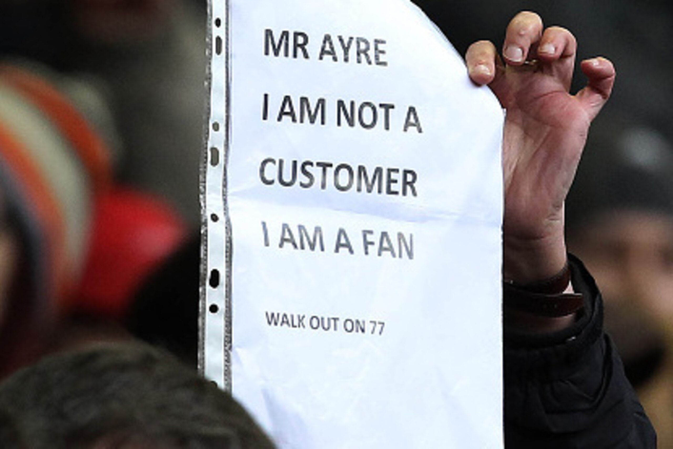A Liverpool fan holds a poster denouncing the the announcement of a rise in ticket prices during the English Premier League football match between Liverpool and Sunderland at Anfield in Liverpool, northwest England, on February 6, 2016. / AFP / LINDSEY PA