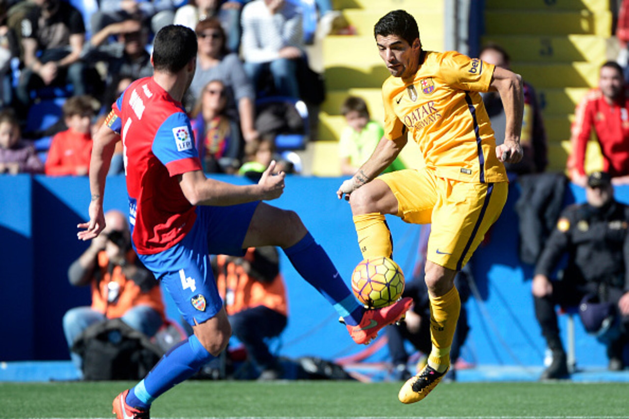 Levante's defender David Navarro (L) vies with Barcelona's Uruguayan forward Luis Suarez during the Spanish league football match Levante UD vs FC Barcelona at the Ciutat de Valencia stadium in Valencia on February 7, 2016. AFP PHOTO / JOSE JORDAN / AFP /