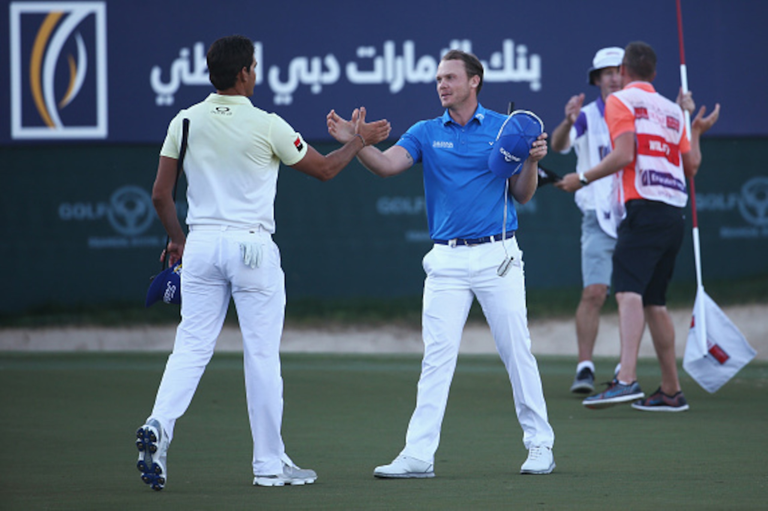DUBAI, UNITED ARAB EMIRATES - FEBRUARY 07: Danny Willett of England celebrates his victory on the 18th green as he shakes hands with Rafa Cabrera-Bello of Spain during the final round of the Omega Dubai Desert Classic at the Emirates Golf Club on Februar DUBAI, UNITED ARAB EMIRATES - FEBRUARY 07: Danny Willett of England celebrates his victory on the 18th green as he shakes hands with Rafa Cabrera-Bello of Spain during the final round of the Omega Dubai Desert Classic at the Emirates Golf Club on Februar