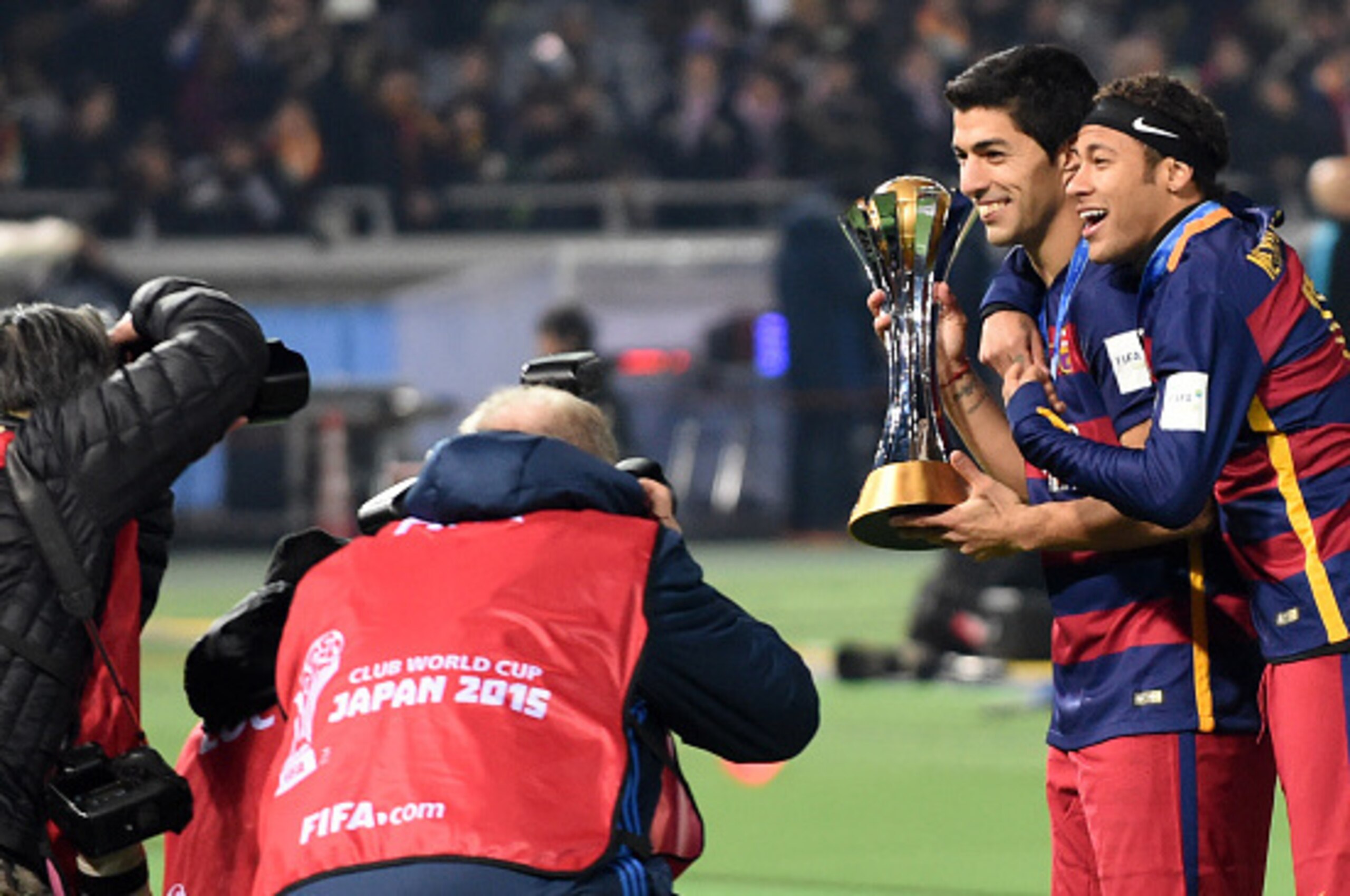 Barcelona forward Luis Suarez (2nd R) and Neymar (R) hold the FIFA Club World Cup trophy during the awarding ceremony at the Club World Cup football tournament final in Yokohama, suburban Tokyo on December 20, 2015.    AFP PHOTO / TOSHIFUMI KITAMURA / AFP