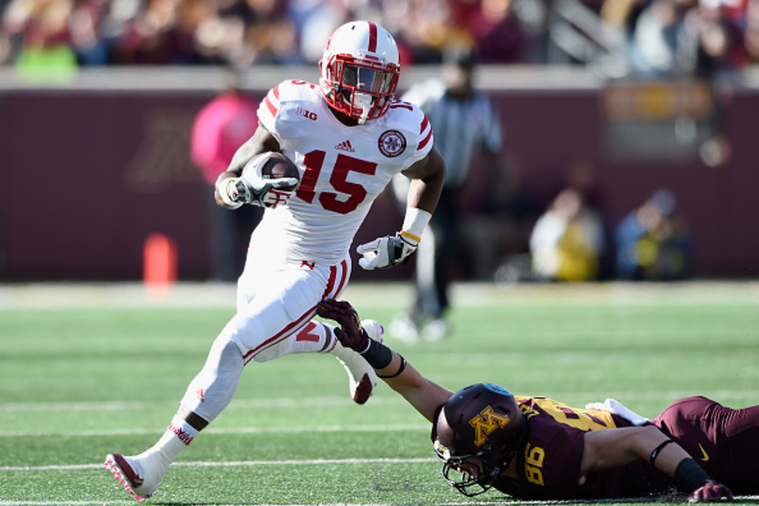 MINNEAPOLIS, MN - OCTOBER 17: De'Mornay Pierson-El #15 of the Nebraska Cornhuskers avoids a tackle by Brandon Lingen #86 of the Minnesota Golden Gophers as he returns a punt during the first quarter of the game on October 17, 2015 at TCF Bank Stadium in M