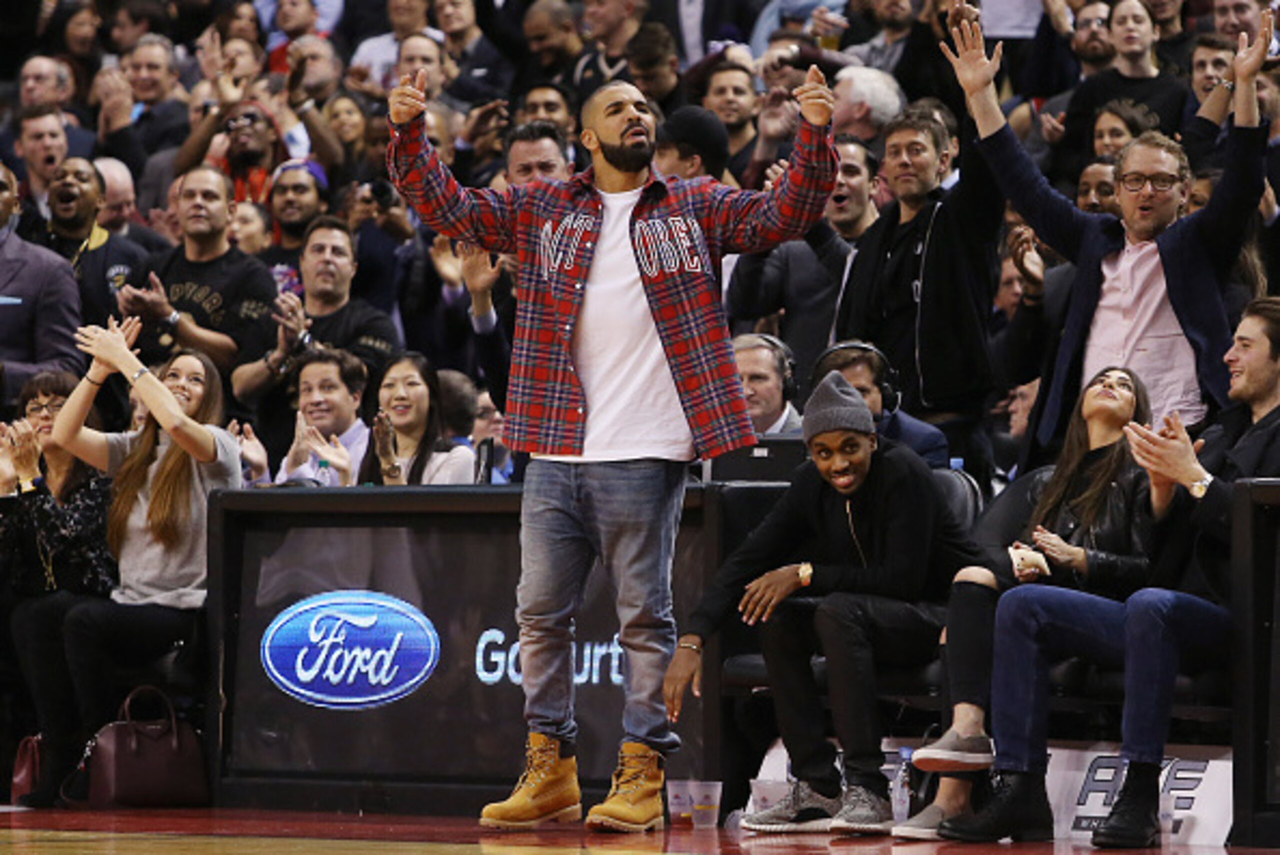 TORONTO, ON - NOVEMBER 25:  Singer Drake celebrates a Raptors score on 'Drake Night' during an NBA game between the Cleveland Cavaliers and the Toronto Raptors at the Air Canada Centre on November 25, 2015 in Toronto, Ontario, Canada.  NOTE TO USER: User 