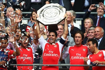 LONDON, ENGLAND - AUGUST 10: Captain Mikel Arteta of Arsenal holds up the trophy alongside team-mates Alex Oxlade-Chamberlain (L) Tomas Rosicky and Santi Cazorla after winning the FA Community Shield match between Manchester City and Arsenal at Wembley St