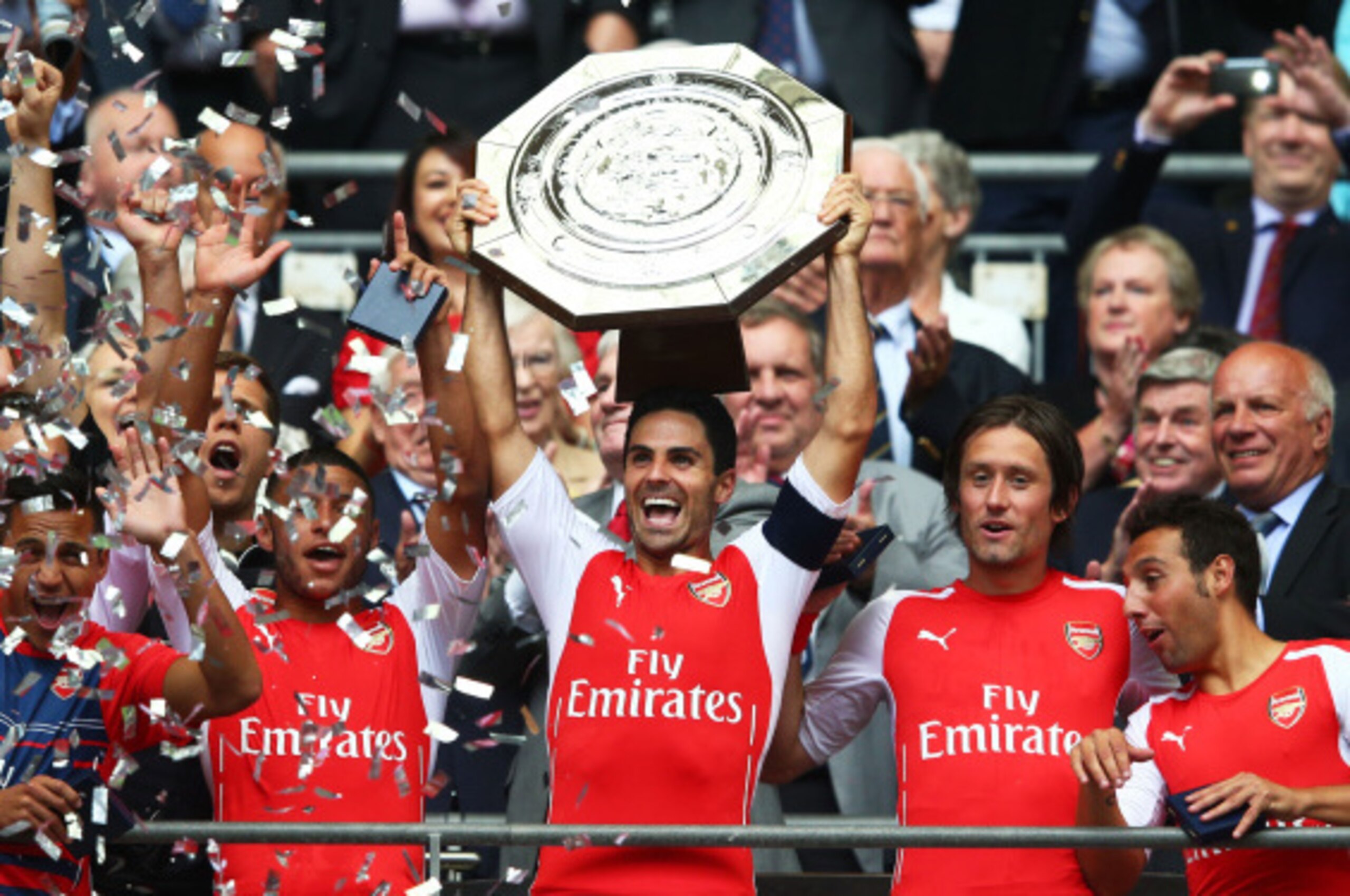 LONDON, ENGLAND - AUGUST 10: Captain Mikel Arteta of Arsenal holds up the trophy alongside team-mates Alex Oxlade-Chamberlain (L) Tomas Rosicky and Santi Cazorla after winning the FA Community Shield match between Manchester City and Arsenal at Wembley St