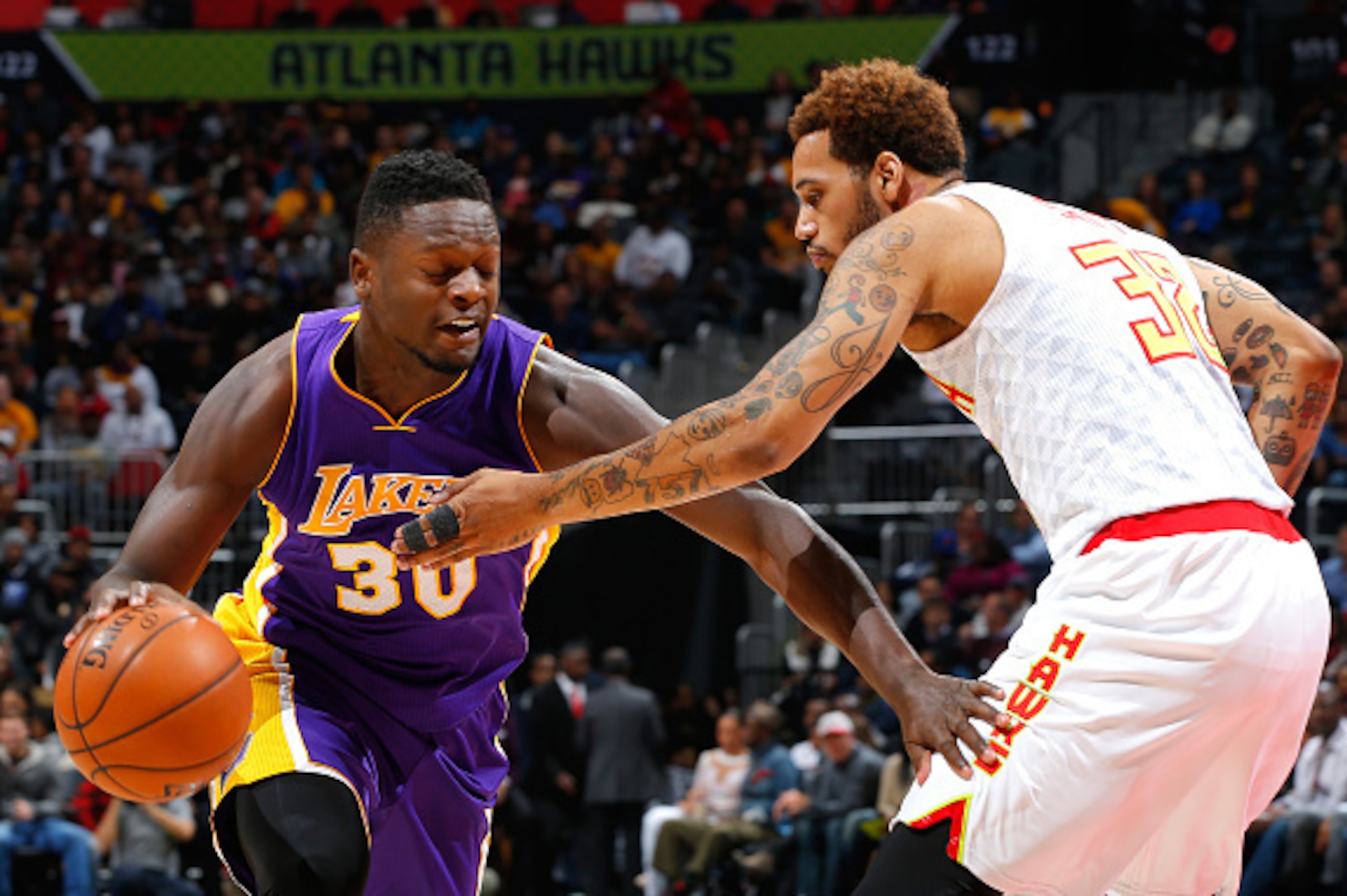 ATLANTA, GA - DECEMBER 04:  Julius Randle #30 of the Los Angeles Lakers drives against Mike Scott #32 of the Atlanta Hawks at Philips Arena on December 4, 2015 in Atlanta, Georgia.  NOTE TO USER User expressly acknowledges and agrees that, by downloading 