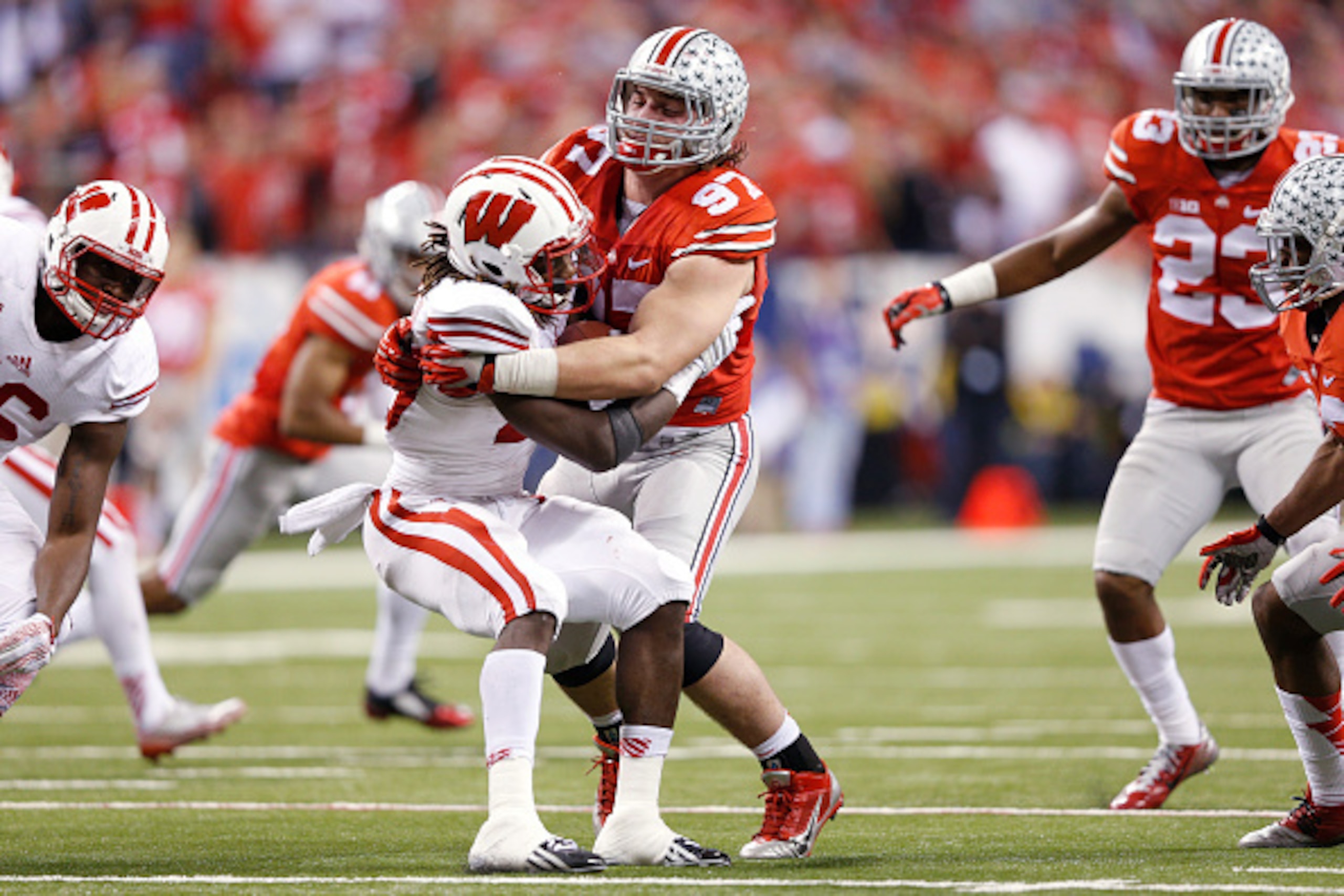 INDIANAPOLIS, IN - DECEMBER 6: Joey Bosa #97 of the Ohio State Buckeyes tackles Melvin Gordon #25 of the Wisconsin Badgers during the Big Ten Championship at Lucas Oil Stadium on December 6, 2014 in Indianapolis, Indiana. Ohio State defeated Wisconsin 59-
