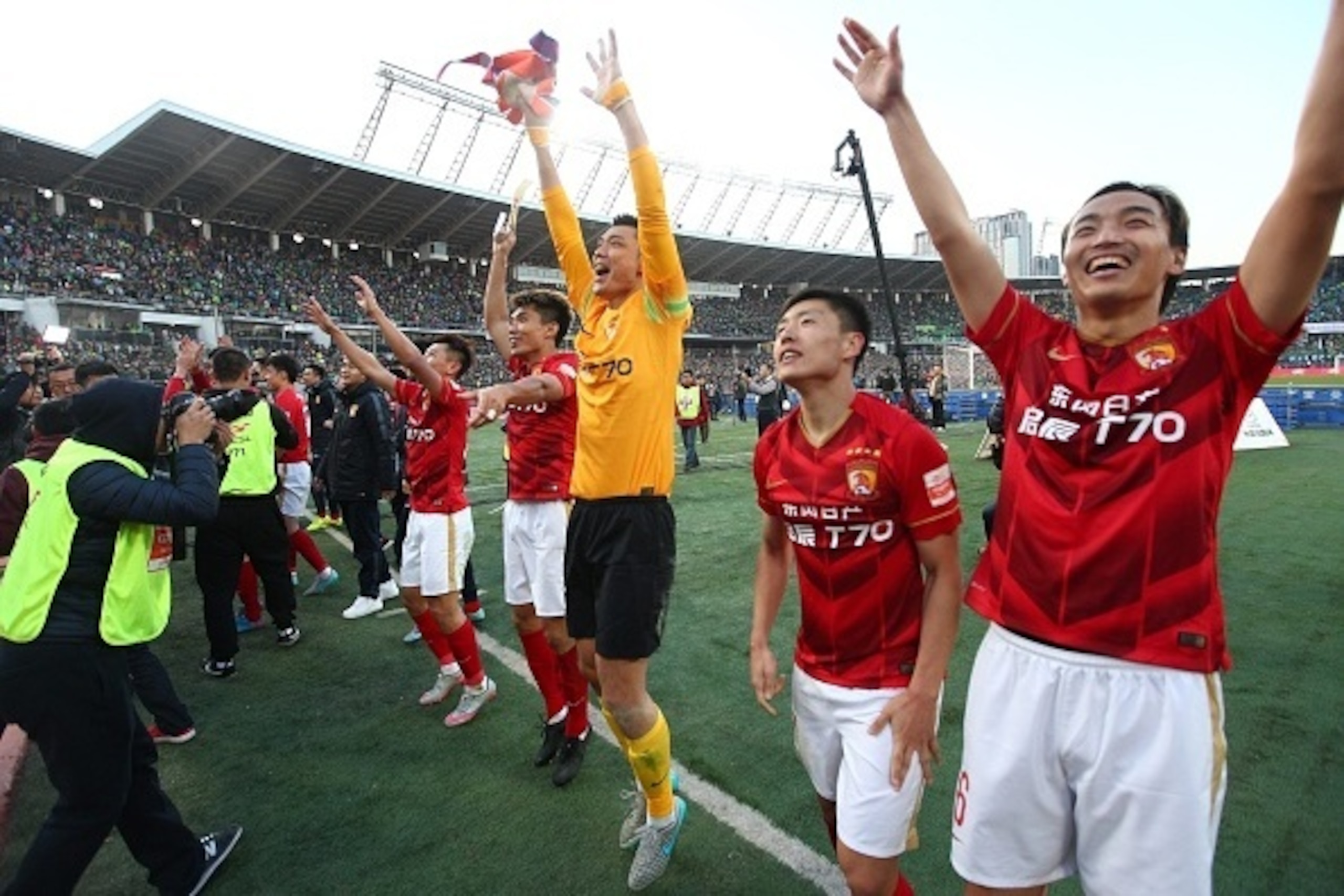 Guangzhou Evergrande's players celebrate after clinching the Chinese football championship in Beijing on October 31, 2015. Phil Scolari's Evergrande won 2-0 away to Beijing Guoan to finish two points clear of Sven-Goran Eriksson's Shanghai SIPG on a drama