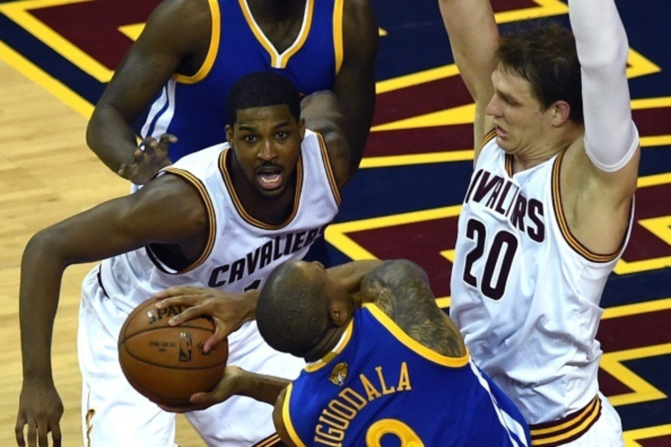Golden State Warriors Andre Iguodala  (C) is cornered by the Cleveland Cavaliers Timofey Mozgov (R) and Tristan Thompson (L) during Game 6 of the 2015 NBA Finals June 16, 2015 at the at Quicken Loans Arena in Cleveland, Ohio. AFP PHOTO  / TIMOTHY A. CLARY
