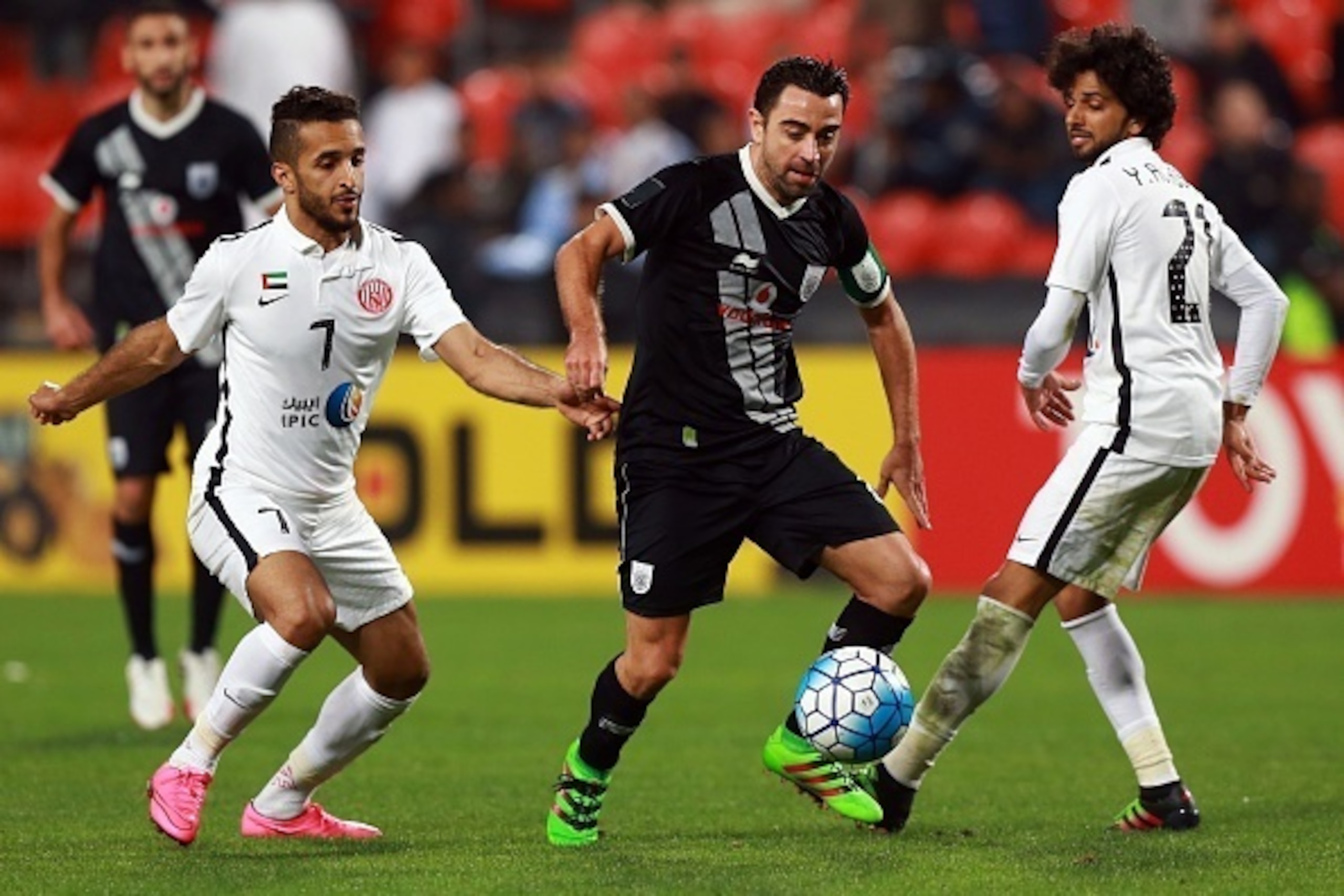 Qatar's Al-Sadd Spanish player Xavi Hernandez (C) dribbles the ball between UAE's al-Jazira player Ali Mabkout (L) and Yaqoub al-Hosani (R) during their AFC Champions League third round qualifying football match at the Mohammed Bin Zayed Stadium in Abu Dh