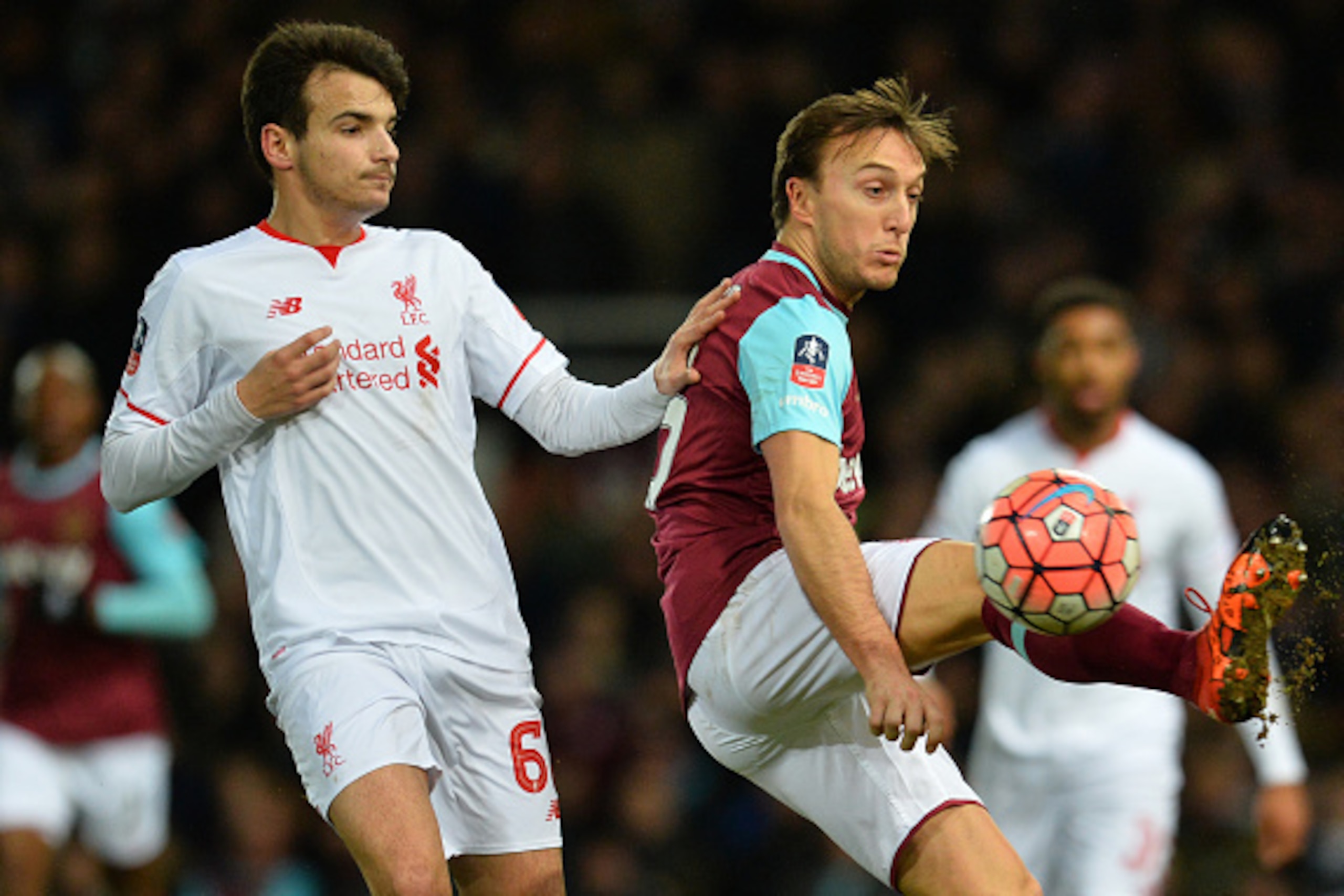 Liverpool's Spanish midfielder Pedro Chirivella (L) vies with West Ham United's English midfielder Mark Noble during the English FA Cup fourth round replay football match between West Ham United and Liverpool at The Boleyn Ground in Upton Park, east Londo