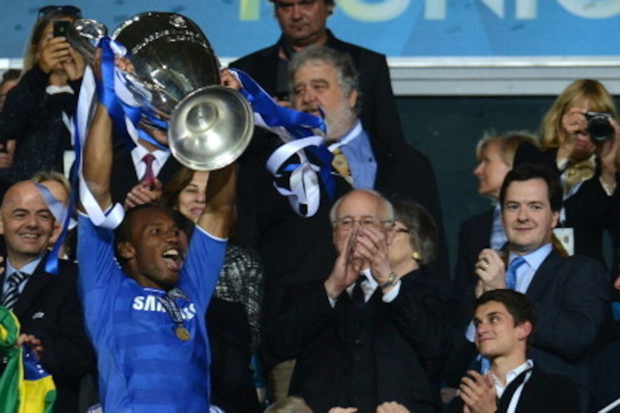Chelsea's Ivorian forward Didier Drogba (L) holds the trophy next to Chelsea's Italian interim manager Roberto Di Matteo (R) after wining the UEFA Champions League final football match between FC Bayern Muenchen and Chelsea FC on May 19, 2012 at the Fussb