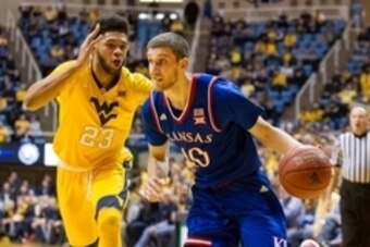 Jan 12, 2016; Morgantown, WV, USA; Kansas Jayhawks guard Sviatoslav Mykhailiuk (10) drives past West Virginia Mountaineers forward Esa Ahmad (23) during the first half at the WVU Coliseum. Mandatory Credit: Ben Queen-USA TODAY Sports