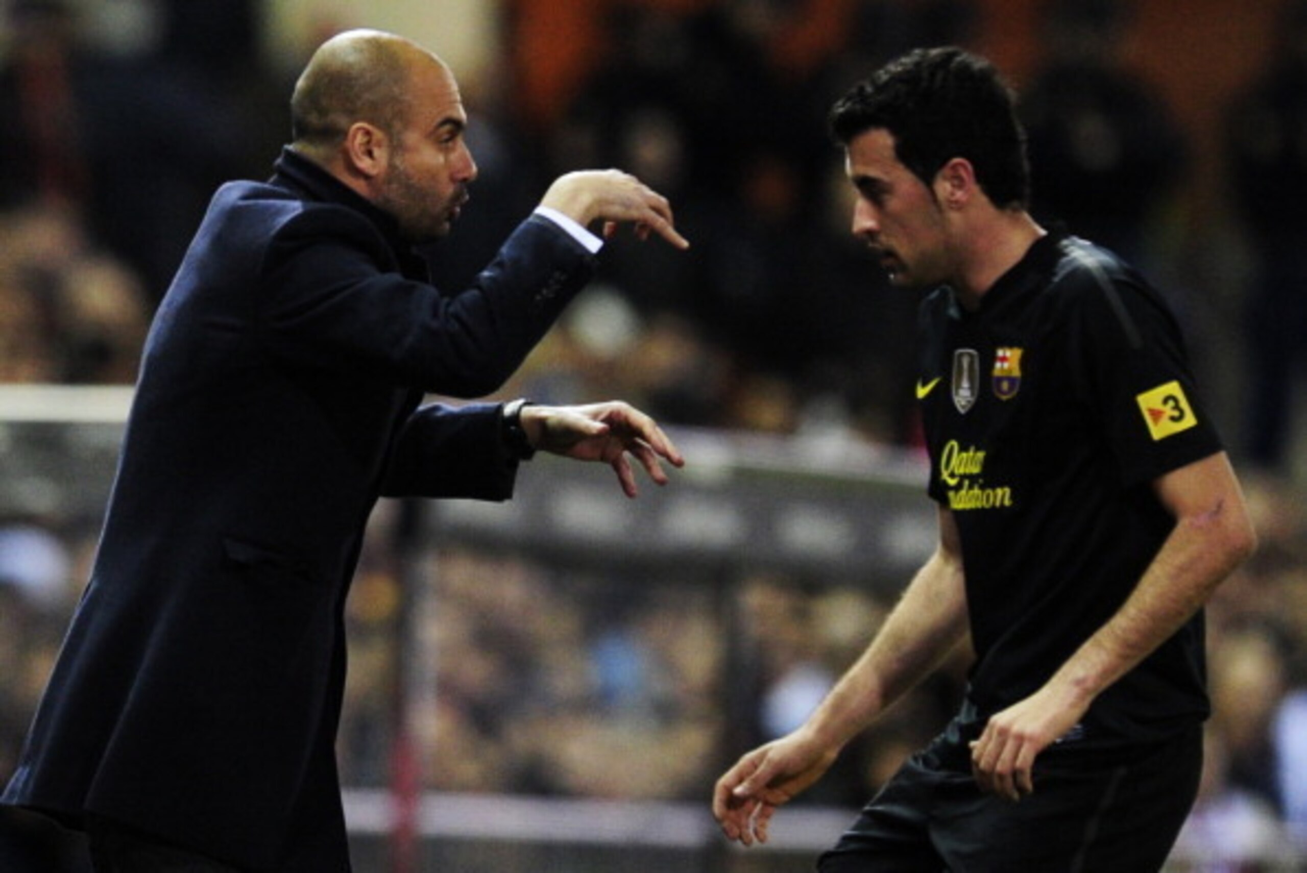 Barcelona's coach Josep Guardiola (L) speaks with midfielder Sergio Busquets during the Spanish League football match between Atletico de Madrid and Barcelona at the Vicente Calderon stadium in Madrid on February 26, 2012. AFP PHOTO/JAVIER SORIANO (Phot Barcelona's coach Josep Guardiola (L) speaks with midfielder Sergio Busquets during the Spanish League football match between Atletico de Madrid and Barcelona at the Vicente Calderon stadium in Madrid on February 26, 2012. AFP PHOTO/JAVIER SORIANO (Phot
