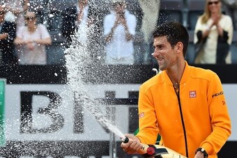 Novak Djokovic of Serbia sprays Champagne after winning the men's final match against Swiss Roger Federer at the ATP Tennis Open on May 17, 2015 at the Foro Italico in Rome.     AFP PHOTO / GABRIEL BOUYS        (Photo credit should read GABRIEL BOUYS/AFP/