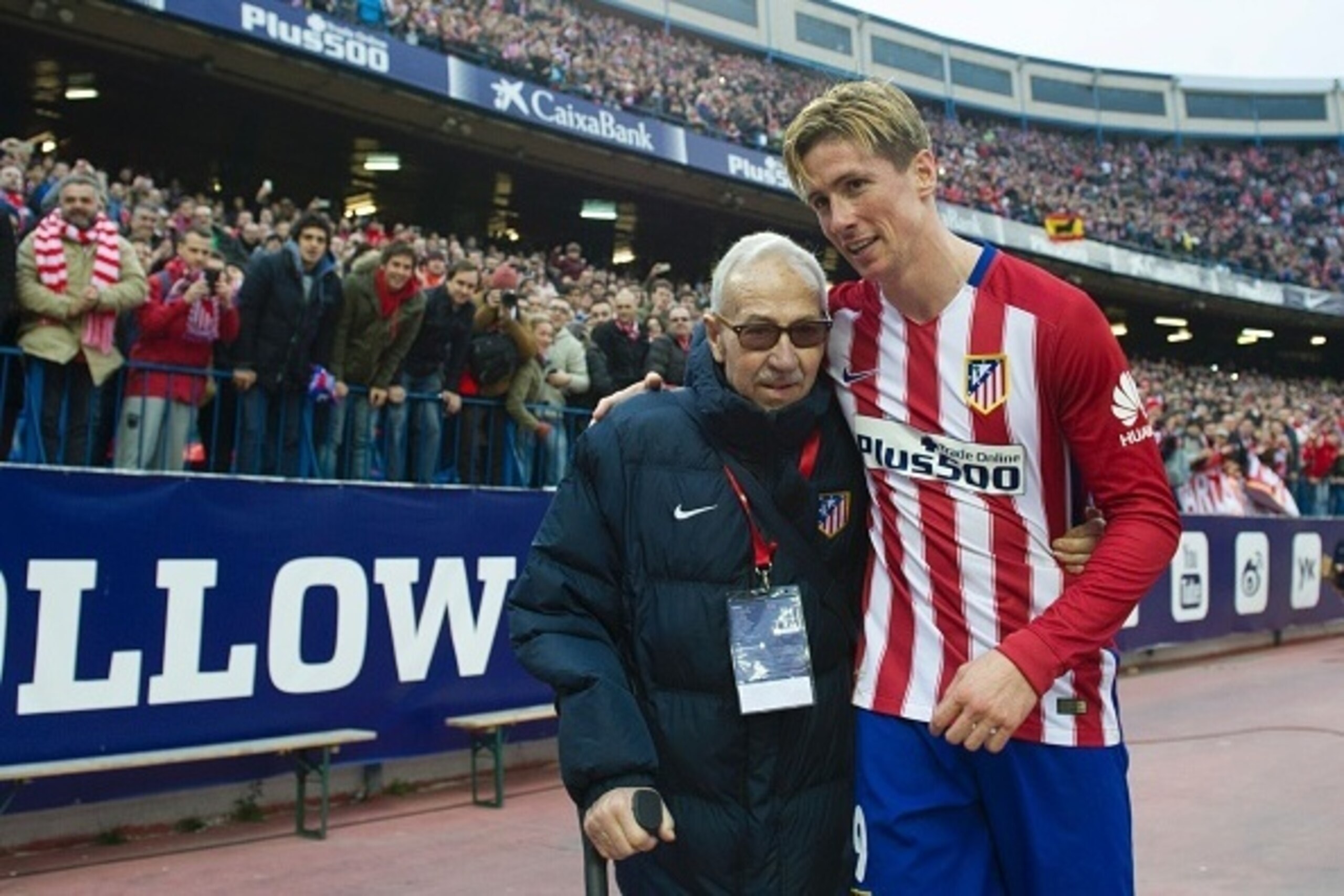 Atletico Madrid's forward Fernando Torres (R) walks with founder of the Atletico de Madrid Football College Manuel Brinas after the Spanish league football match Club Atletico de Madrid vs SD Eibar at the Vicente Calderon stadium in Madrid on February 6, 