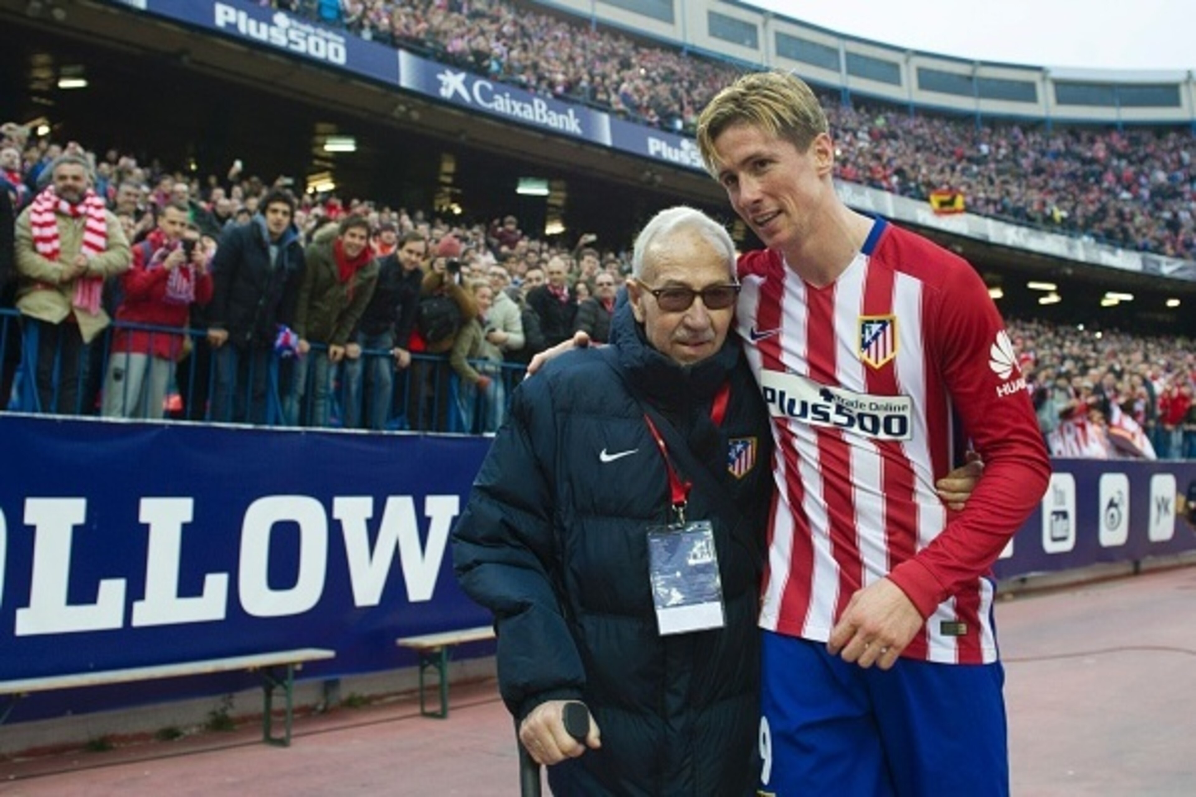 Atletico Madrid's forward Fernando Torres (R) walks with founder of the Atletico de Madrid Football College Manuel Brinas after the Spanish league football match Club Atletico de Madrid vs SD Eibar at the Vicente Calderon stadium in Madrid on February 6, 