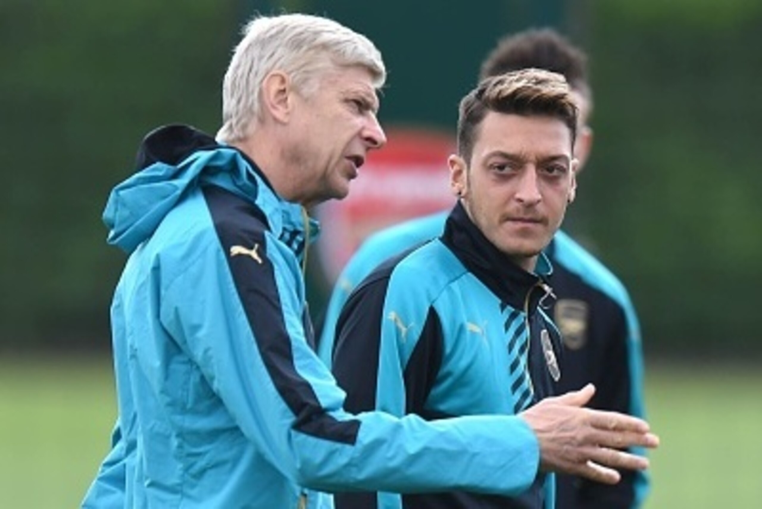 Arsenal manager Arsene Wenger (L) talks with German midfielder Mesut Ozil during a training session at London Colney in St Albans, north London on 28 September, 2015 before a Group F Champions League football match against Olympiakos.   AFP PHOTO/Olly Gre