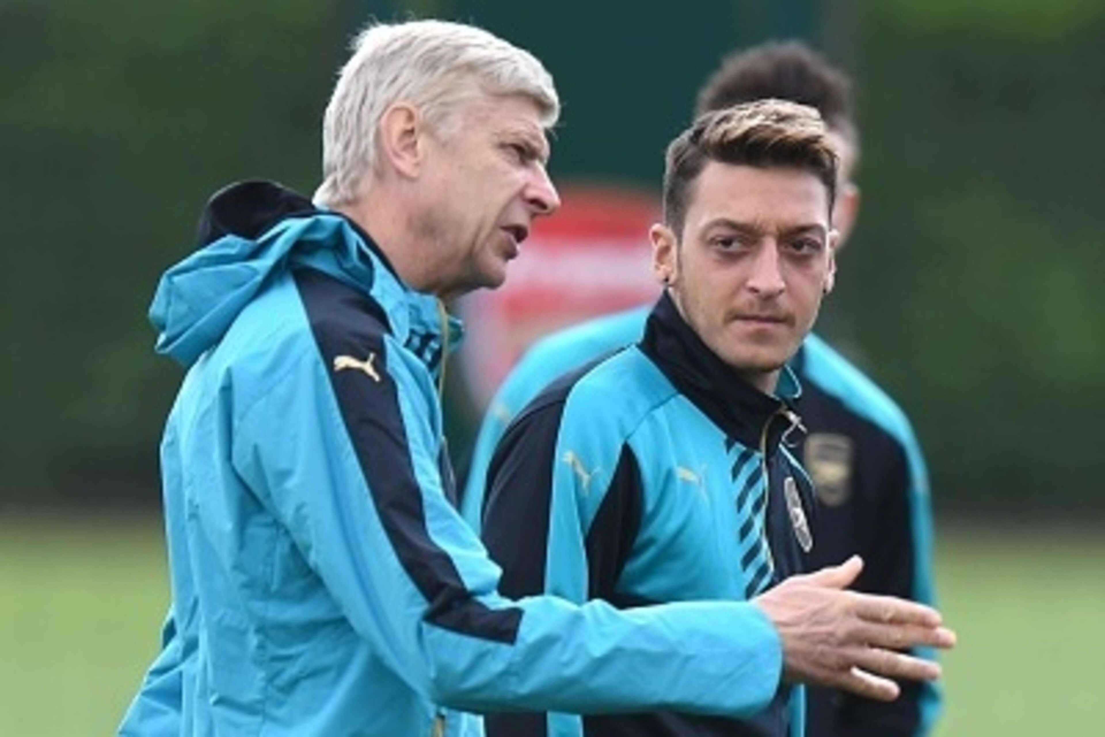 Arsenal manager Arsene Wenger (L) talks with German midfielder Mesut Ozil during a training session at London Colney in St Albans, north London on 28 September, 2015 before a Group F Champions League football match against Olympiakos.   AFP PHOTO/Olly Gre