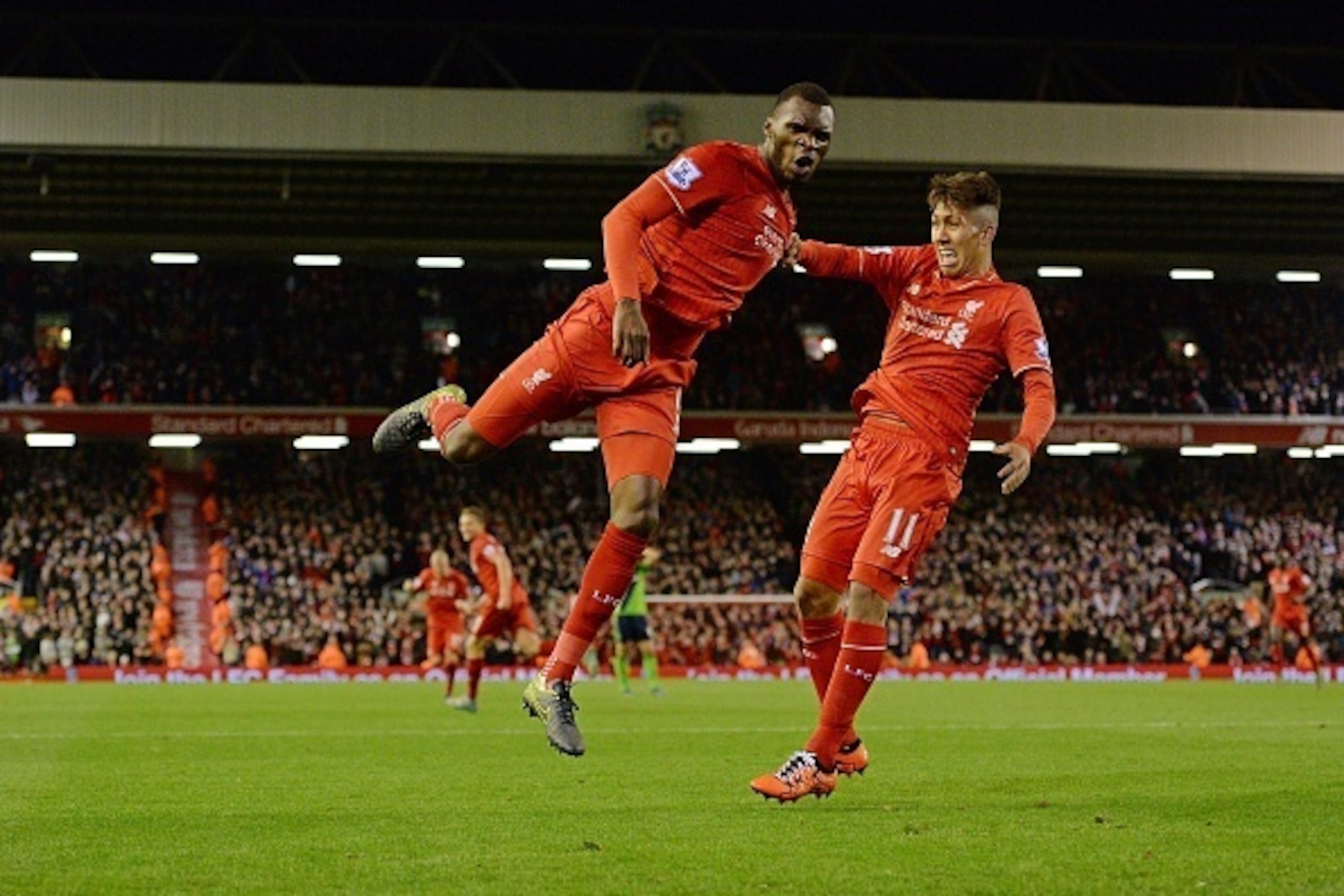 Liverpool's Zaire-born Belgian striker Christian Benteke celebrates with Liverpool's Brazilian midfielder Roberto Firmino (R) after scoring the opening goal of the English Premier League football match between Liverpool and Southampton at Anfield stadium 