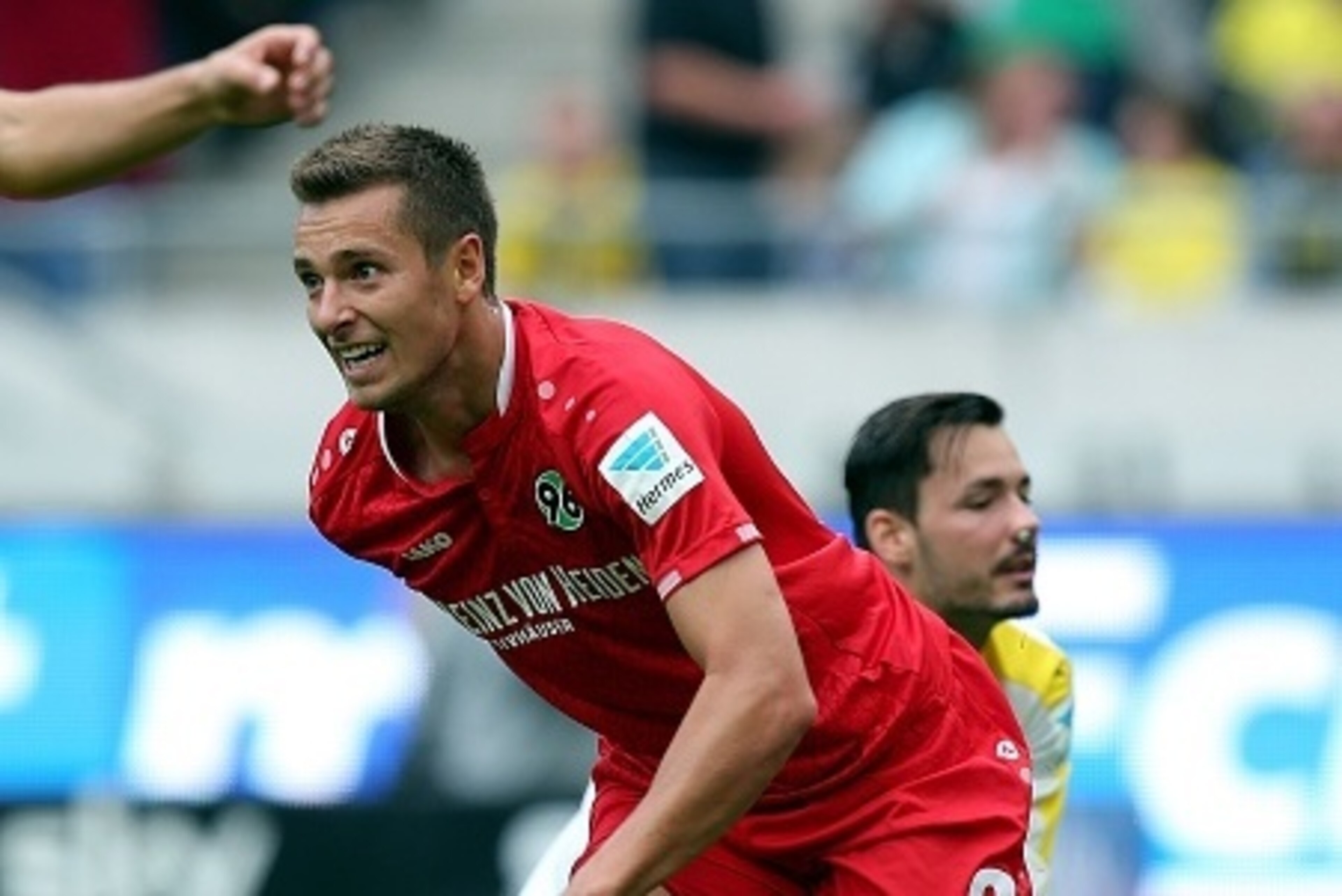Hanover's Polish striker Artur Sobiech (L) celebrates after scoring his team's opening goal in front of Dortmund's goalkeeper Roman Buerki during the German first division Bundesliga football match Hannover 96 v Borussia Dortmund, in Hannover, on Septembe