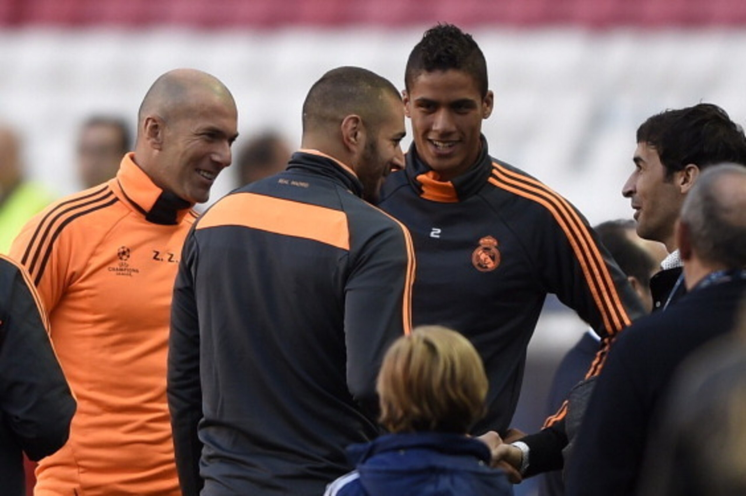 Real Madrid's assistant manager Zinedine Zidane (L) speaks with former Real Madrid forward Raul Gonzalez (R) with Real Madrid's French forward Karim Benzema and Real Madrid's French defender Raphael Varane during a training session on the eve of the UEFA Real Madrid's assistant manager Zinedine Zidane (L) speaks with former Real Madrid forward Raul Gonzalez (R) with Real Madrid's French forward Karim Benzema and Real Madrid's French defender Raphael Varane during a training session on the eve of the UEFA