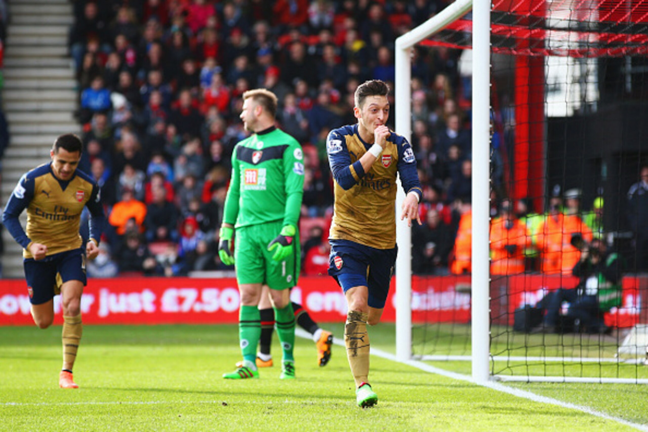 BOURNEMOUTH, ENGLAND - FEBRUARY 07:  Goalkeeper Artur Boruc of Bournemouth looks dejected as Mesut Ozil of Arsenal celebrates as he scores their first goal during the Barclays Premier League match between A.F.C. Bournemouth and Arsenal at the Vitality Sta