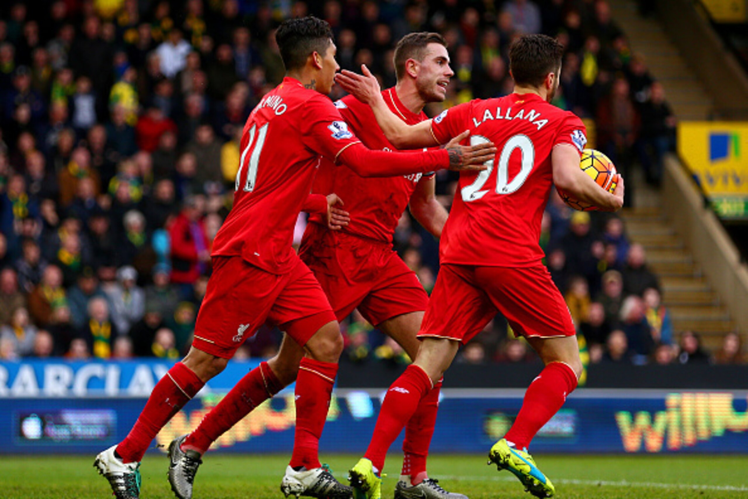 NORWICH, ENGLAND - JANUARY 23: Roberto Firmino (L) of Liverpool ceelbrates scoring his team's third goal with his team mates Jordan Henderson (C) and Adam Lallana (R) during the Barclays Premier League match between Norwich City and Liverpool at Carrow Ro