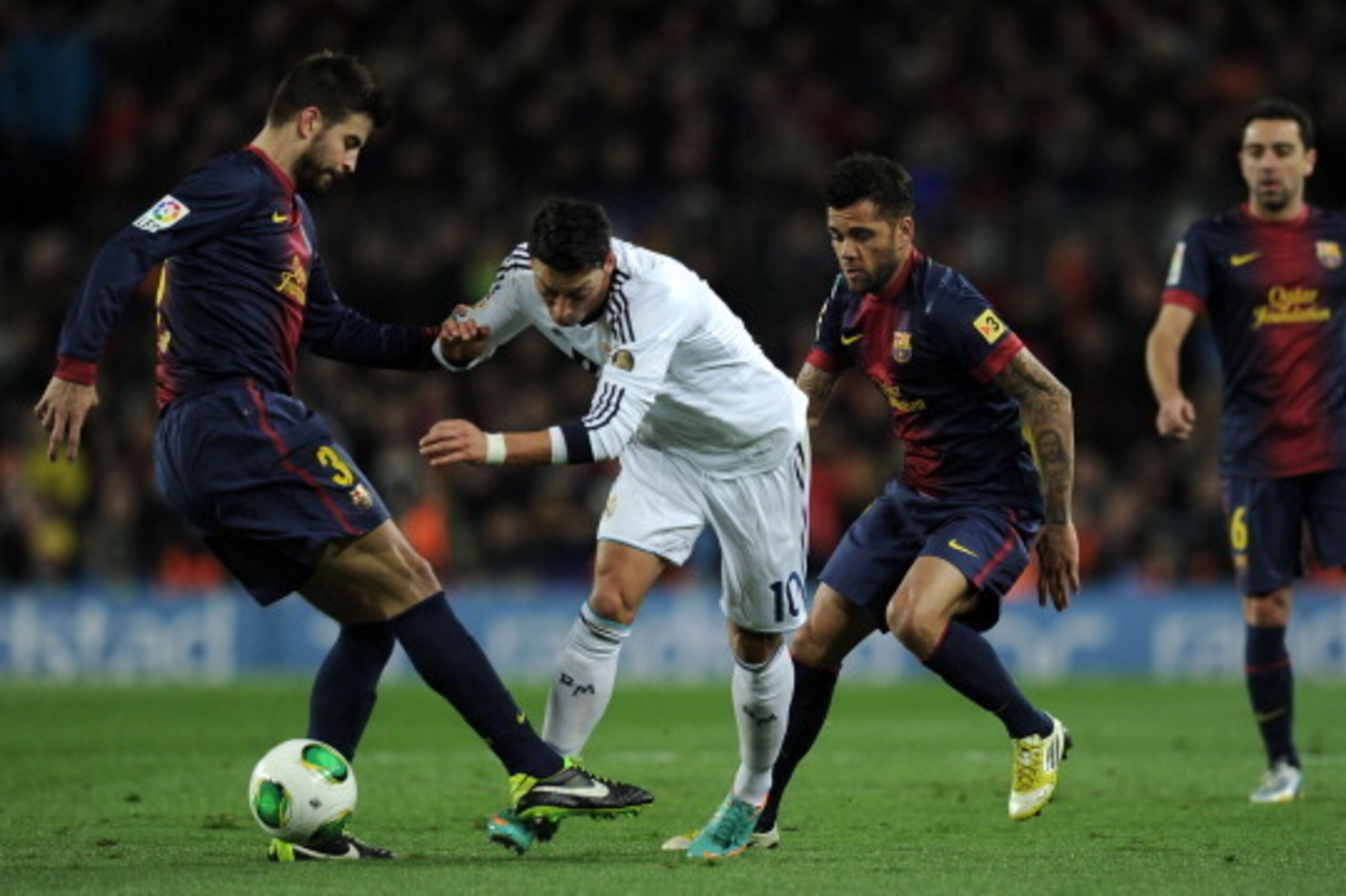 Real Madrid's German midfielder Mesut Ozil (2L) vies with Barcelona's defender Gerard Pique (L), Barcelona's Brazilian defender Dani Alves (3L) and Barcelona's midfielder Xavi Hernandez (4L) during the Spanish Cup semi-final second leg football match FC B Real Madrid's German midfielder Mesut Ozil (2L) vies with Barcelona's defender Gerard Pique (L), Barcelona's Brazilian defender Dani Alves (3L) and Barcelona's midfielder Xavi Hernandez (4L) during the Spanish Cup semi-final second leg football match FC B