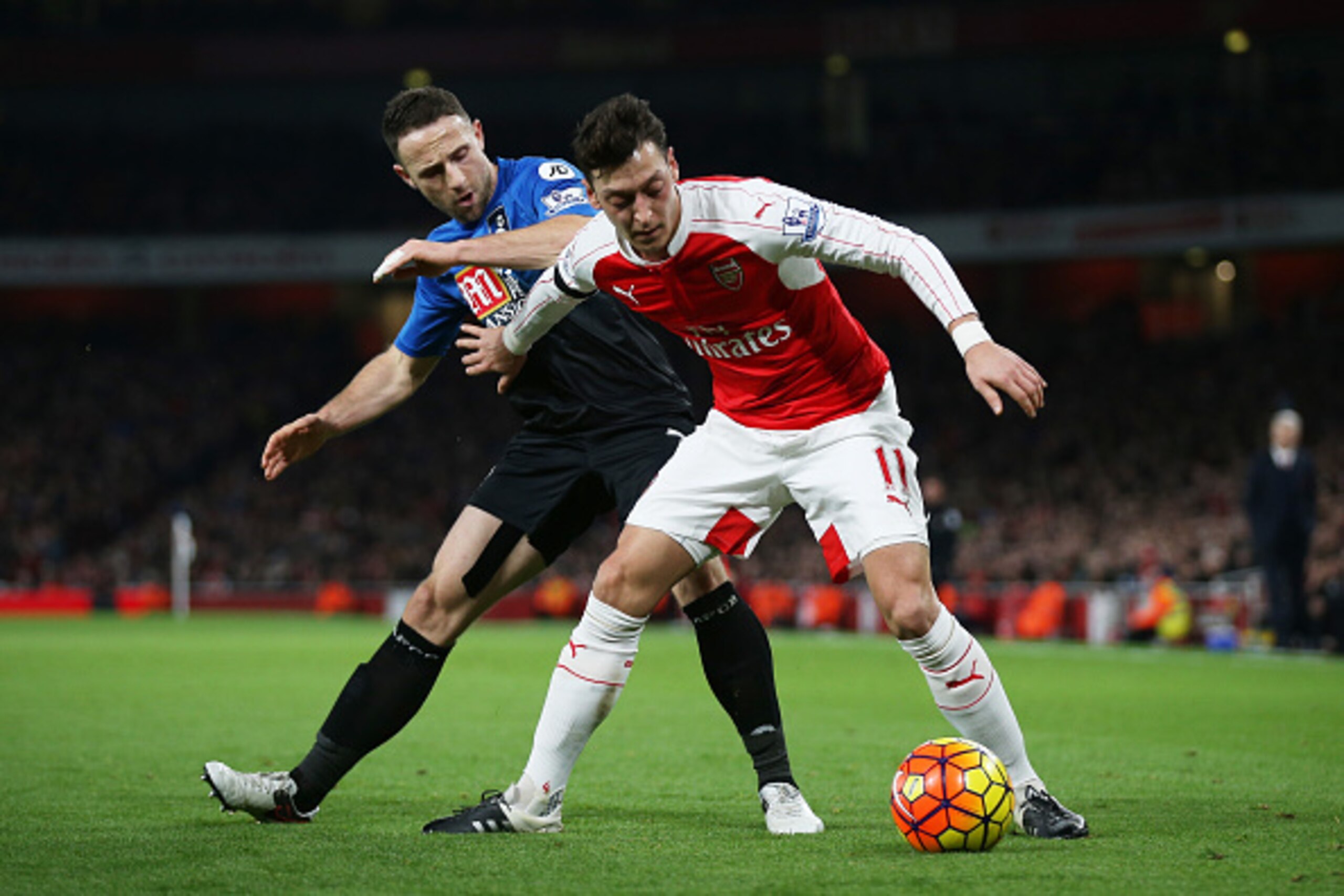 LONDON, ENGLAND - DECEMBER 28: Mesut Ozil of Arsenal controls the ball under pressure of Marc Pugh of Bournemouth during the Barclays Premier League match between Arsenal and A.F.C. Bournemouth at Emirates Stadium on December 28, 2015 in London, England. 