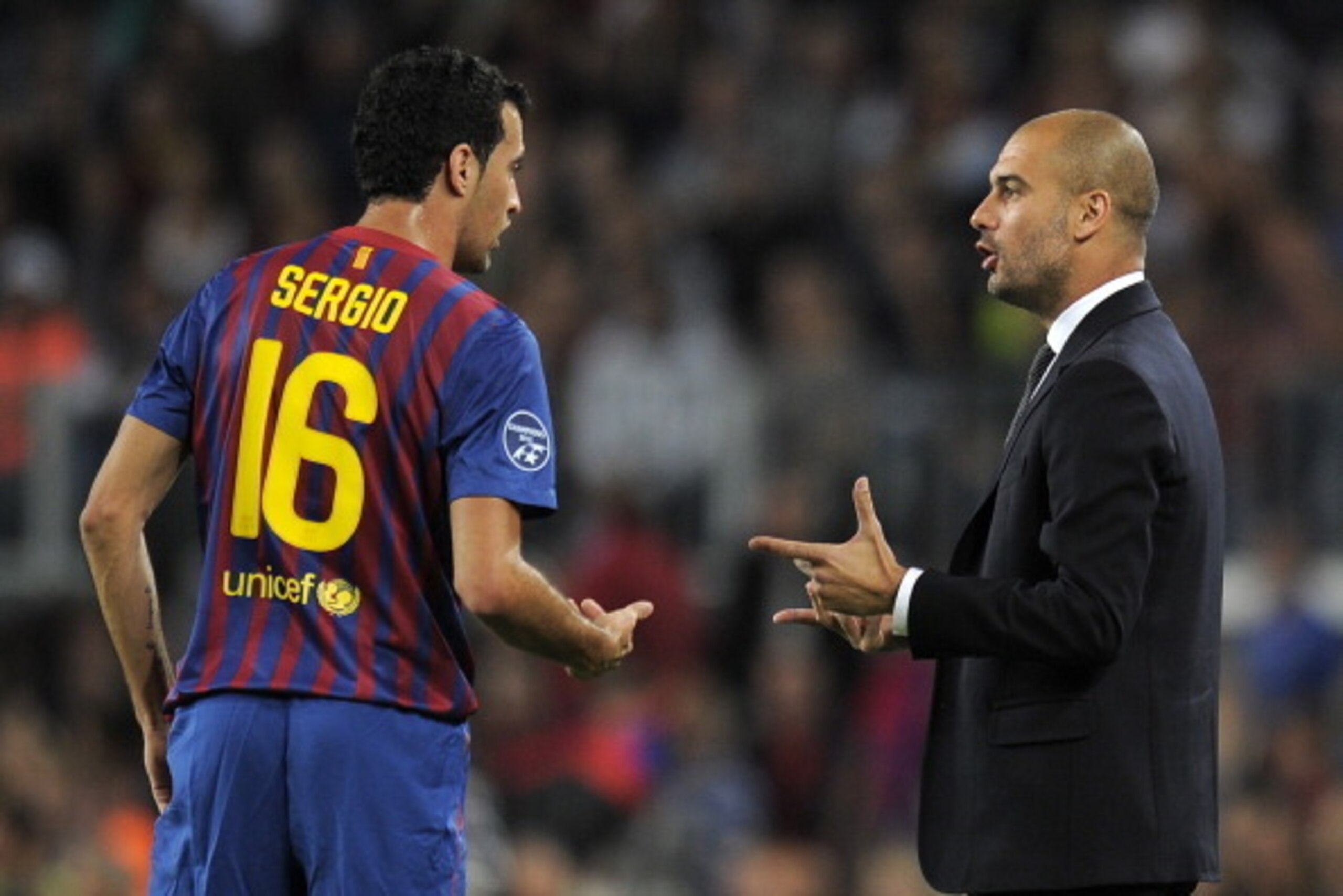 Barcelona's coach Josep Guardiola (R) talks with Barcelona's midfielder Sergio Busquets (L) during the Champions League football match between FC Barcelona and Viktoria Plzen at the Camp Nou stadium in Barcelona on October 19, 2011. AFP PHOTO/LLUIS GENE (