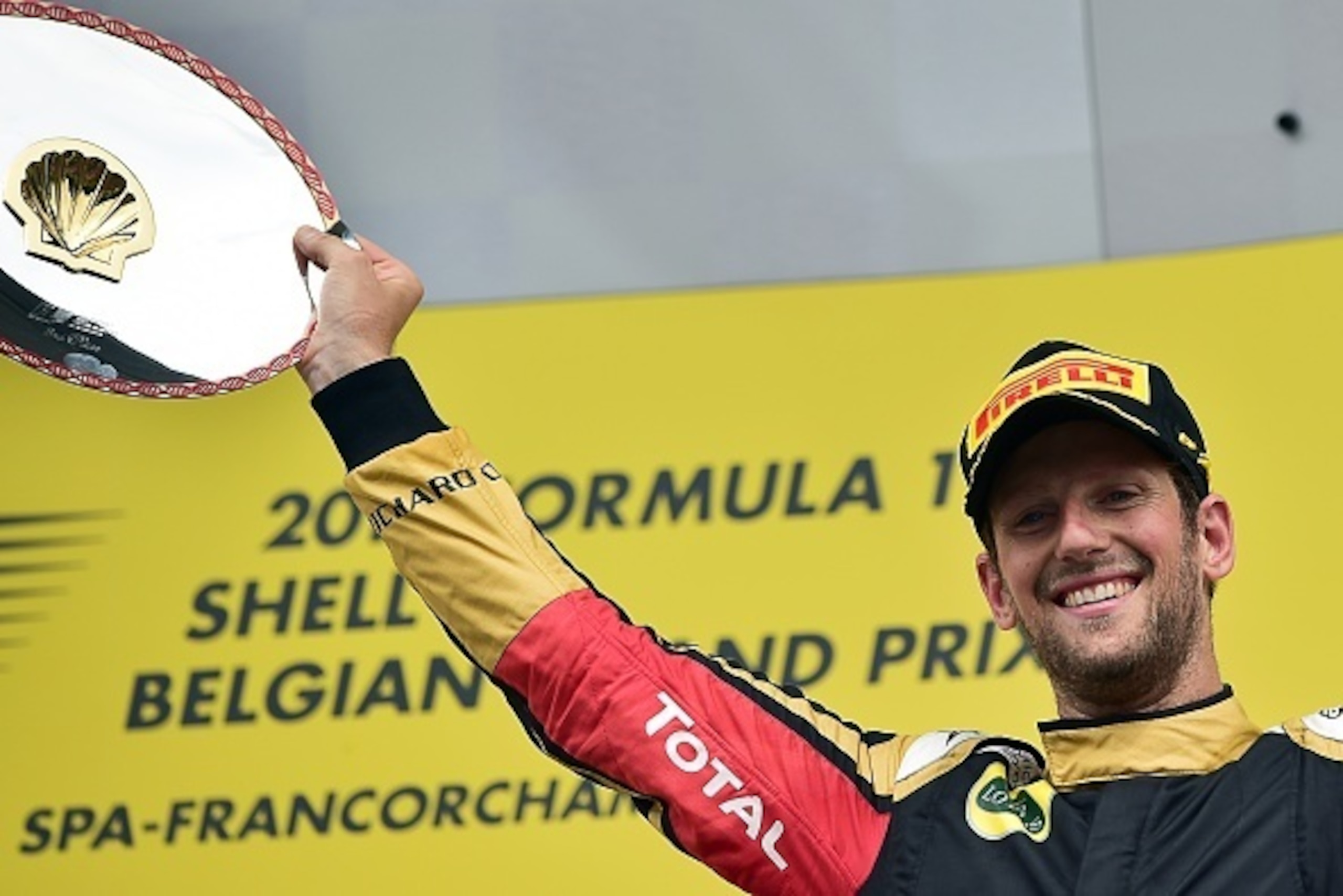 Third-placed Lotus F1 Team's French driver Romain Grosjean celebrates with his trophy on the podium at the Spa-Francorchamps circuit in Spa on August 23, 2015, after the Belgian Formula One Grand Prix. AFP PHOTO / ANDREJ ISAKOVIC        (Photo credit shou
