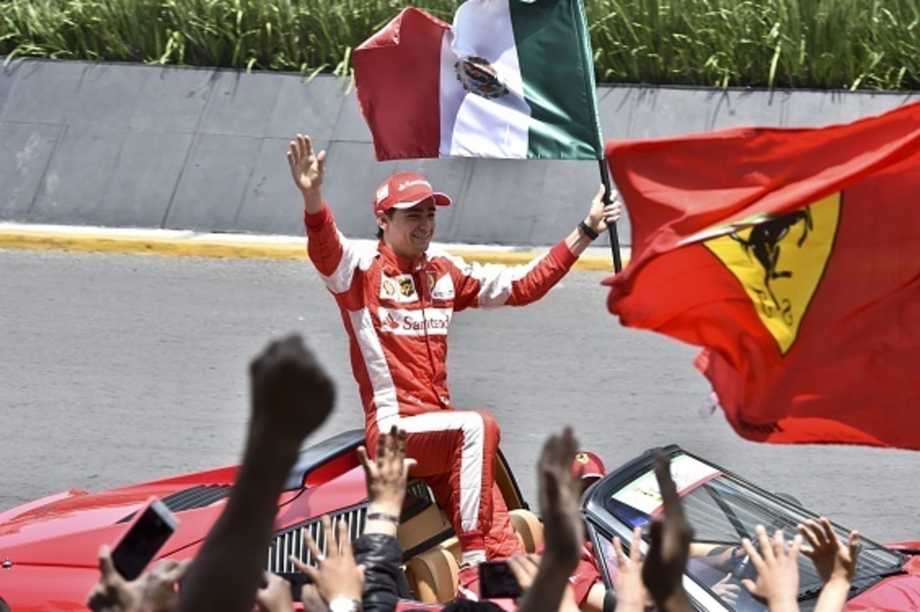 Ferrari's Mexican driver Esteban Gutierrez waves the Mexican Flag during a street demonstration along Reforma Avenue in Mexico City, on August 2, 2015. The Grand Prix of Mexico will be held on November 1 at the 'Autodromo Hermanos Rodriguez'. AFP PHOTO/ Y