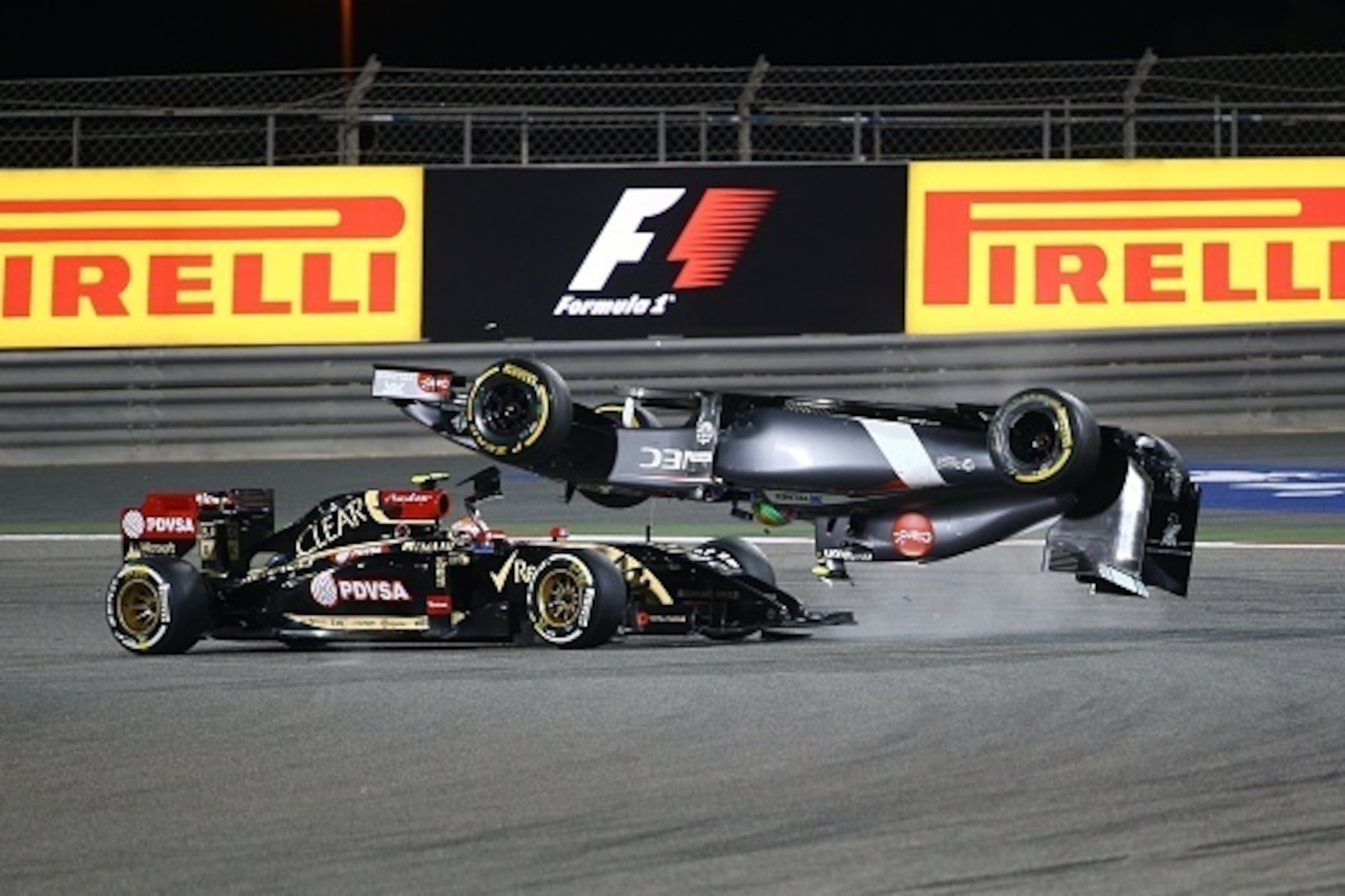 Sauber driver Esteban Gutierrez of Mexico crashes ahead of Lotus driver Pastor Maldonado of Venezuela during the Formula One Bahrain Grand Prix at Sakhir circuit in Manama on April 6, 2014.  AFP PHOTO / MARWAN NAAMANI        (Photo credit should read MARW