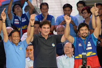Philippine presidential candidate Jejomar Binay (L), who is leader of the opposition and current Philippine vice president, gestures onstage with his vice-presidential candidate Senator Gringo Honasan (C) plus senatorial candidate and boxing icon Manny Pa