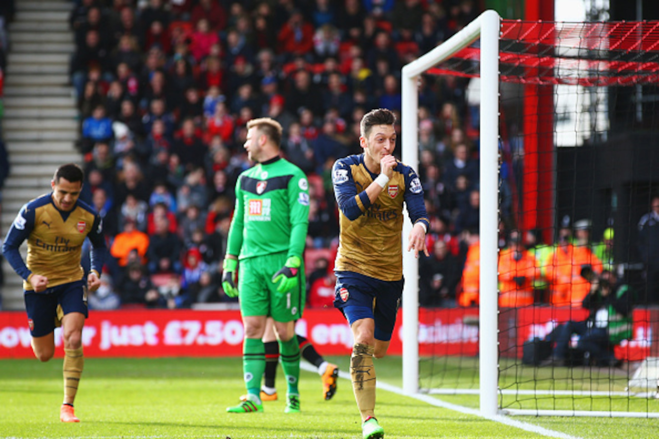 BOURNEMOUTH, ENGLAND - FEBRUARY 07:  Goalkeeper Artur Boruc of Bournemouth looks dejected as Mesut Ozil of Arsenal celebrates as he scores their first goal during the Barclays Premier League match between A.F.C. Bournemouth and Arsenal at the Vitality Sta