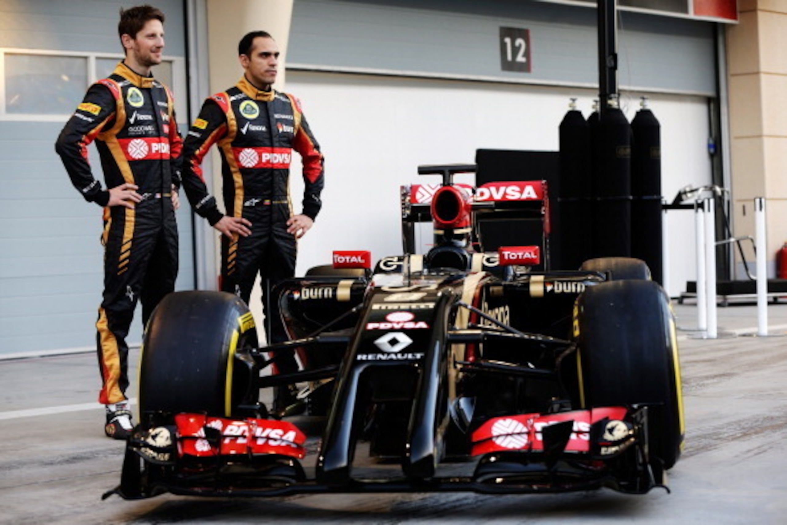BAHRAIN, BAHRAIN - FEBRUARY 20:  Pastor Maldonado (R) of Venezuela and Lotus and Romain Grosjean (L) of France and Lotus stand with the new Lotus E22 following day two of Formula One Winter Testing at the Bahrain International Circuit on February 20, 2014