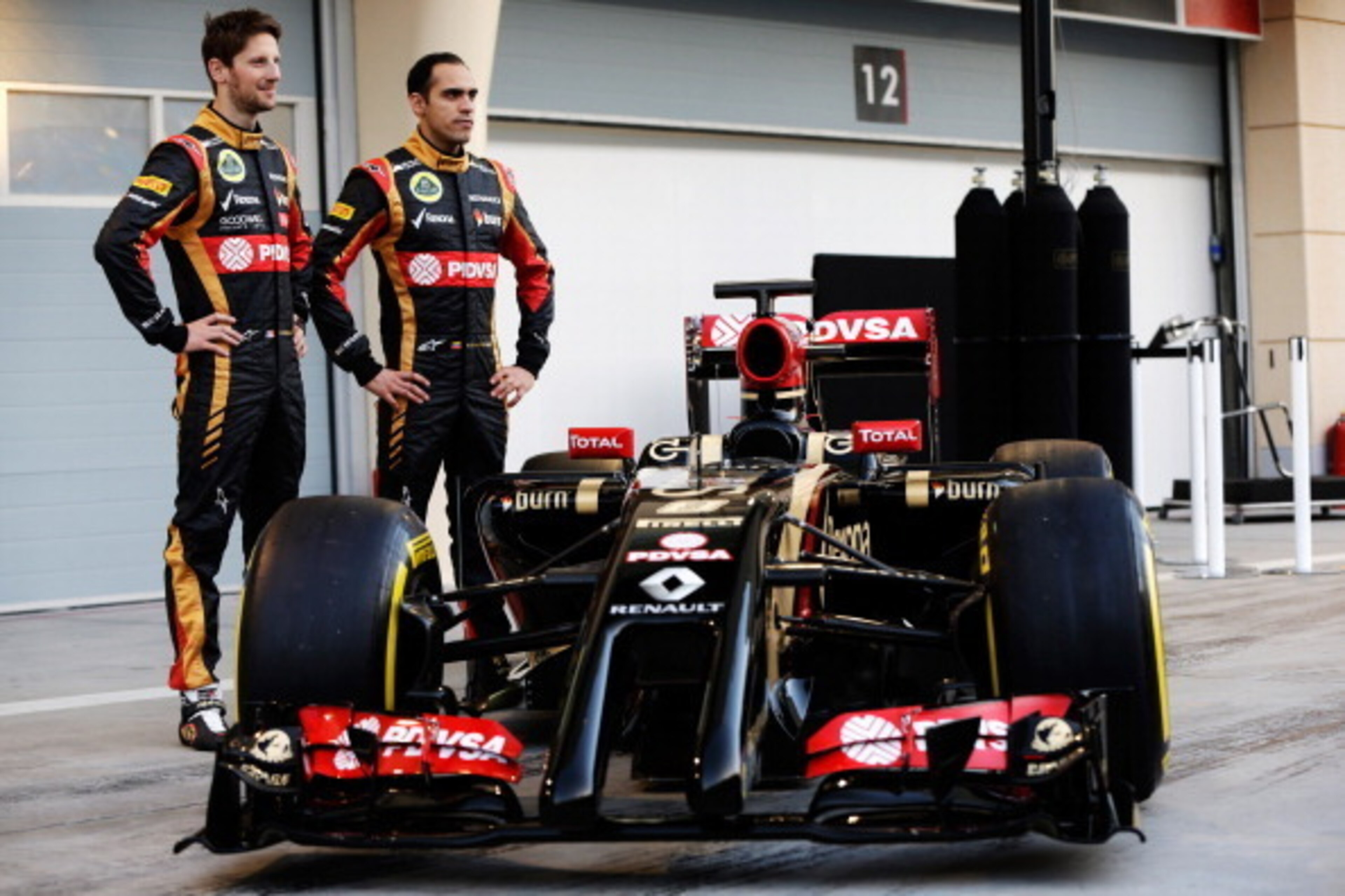 BAHRAIN, BAHRAIN - FEBRUARY 20:  Pastor Maldonado (R) of Venezuela and Lotus and Romain Grosjean (L) of France and Lotus stand with the new Lotus E22 following day two of Formula One Winter Testing at the Bahrain International Circuit on February 20, 2014